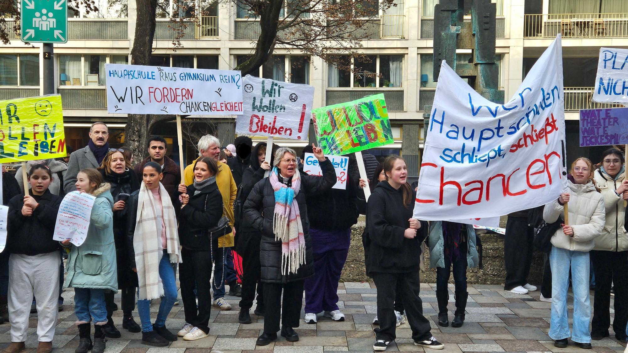 Eltern, Schülerinnen und Schüler und Lehrkräfte demonstrieren vor dem Rathaus.