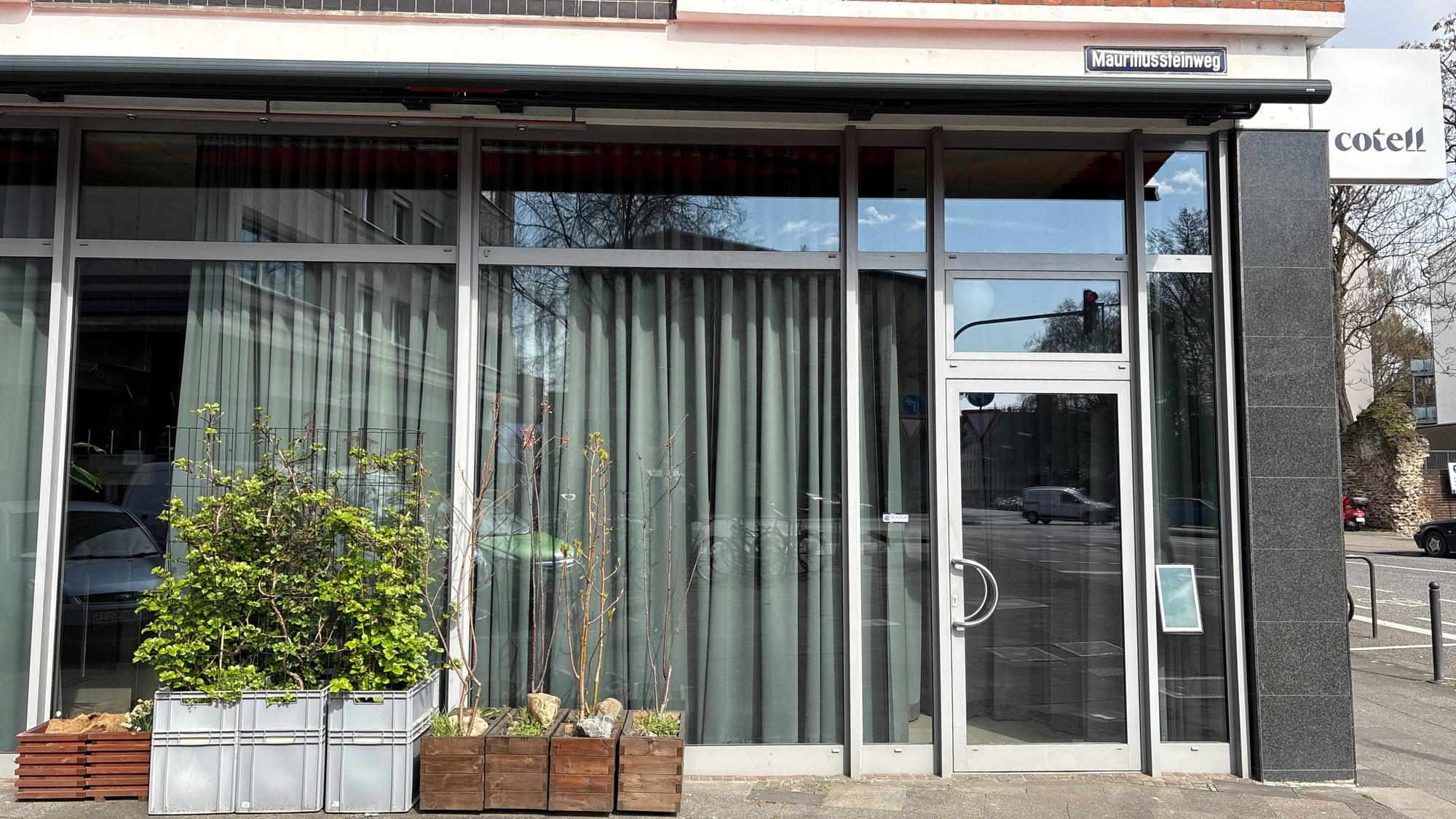 Das Cotell Cologne von außen, vor den Fenstern stehen Blumenkästen, bodenlange Vorhänge vereiteln einen Blick in den Innenraum.