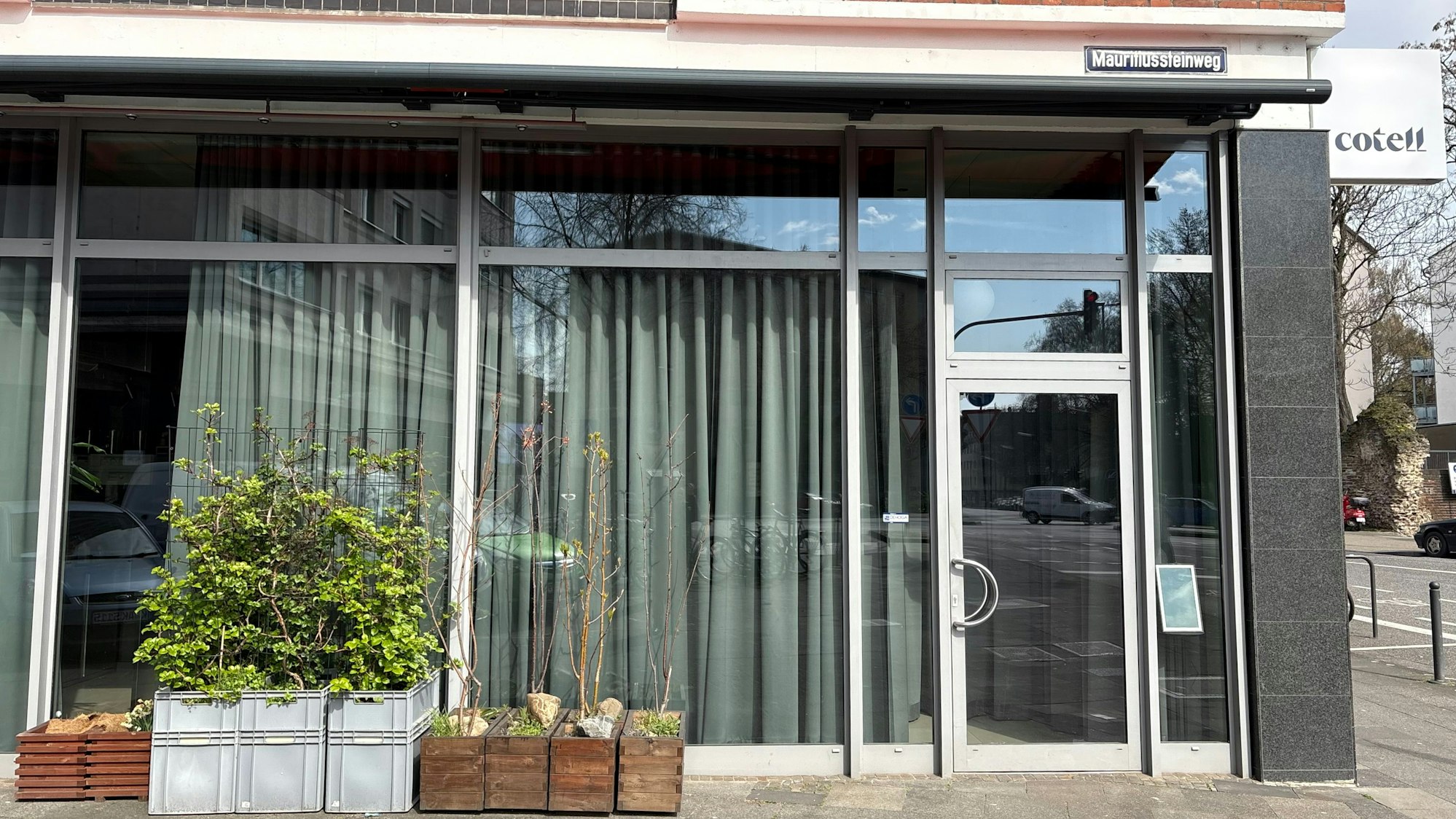 Das Cotell Cologne von außen, vor den Fenstern stehen Blumenkästen, bodenlange Vorhänge vereiteln einen Blick in den Innenraum.