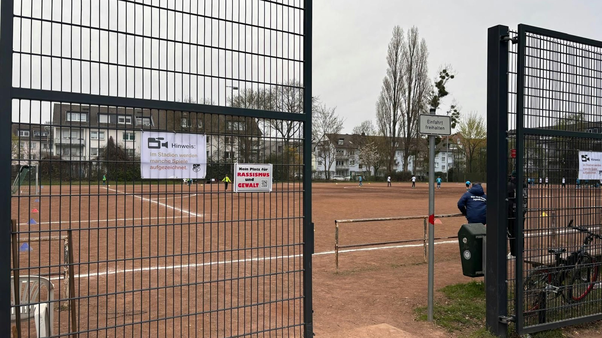 Das Foto zeigt einen Aschenplatz, auf dem Fußball gespielt wird.