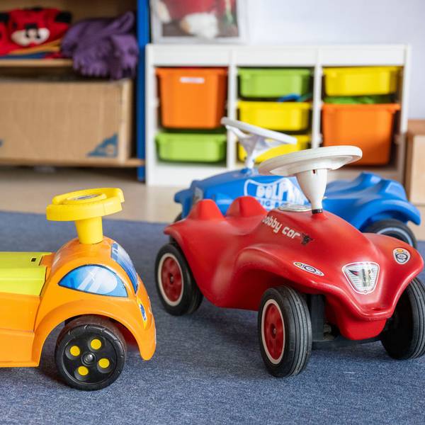 Spielzeugautos stehen in einer Kita.