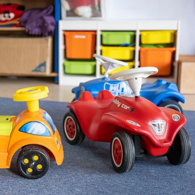 Spielzeugautos stehen in einer Kita.