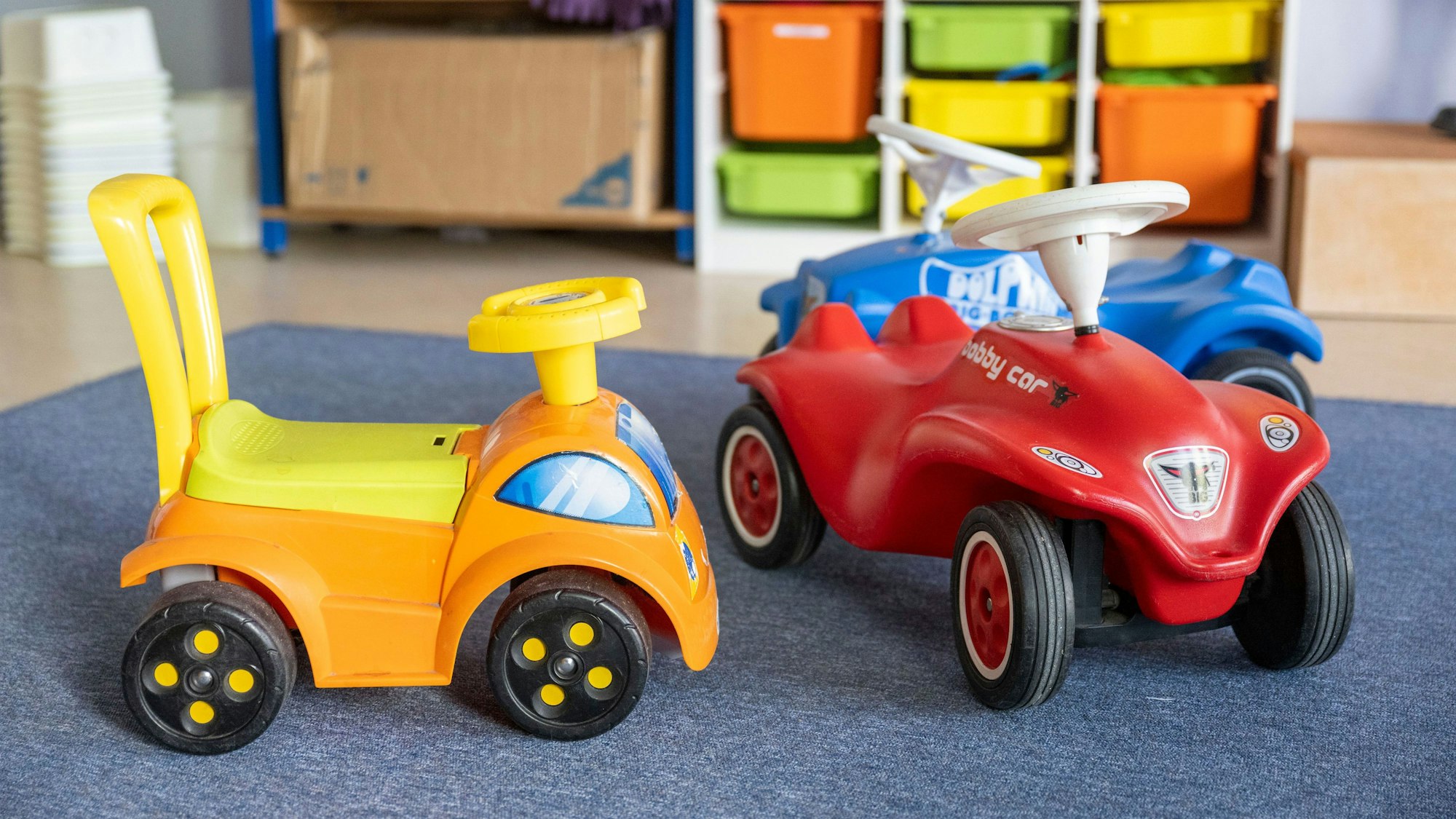 Spielzeugautos stehen in einer Kita.