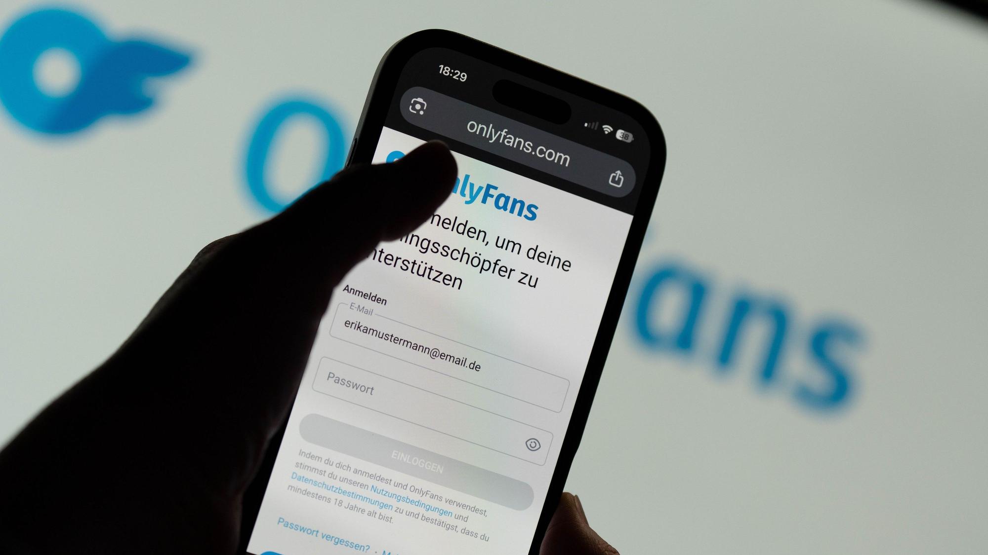 Eine Person öffnet auf dem Handy die Anmeldeseite bei dem Onlinedienst OnlyFans.