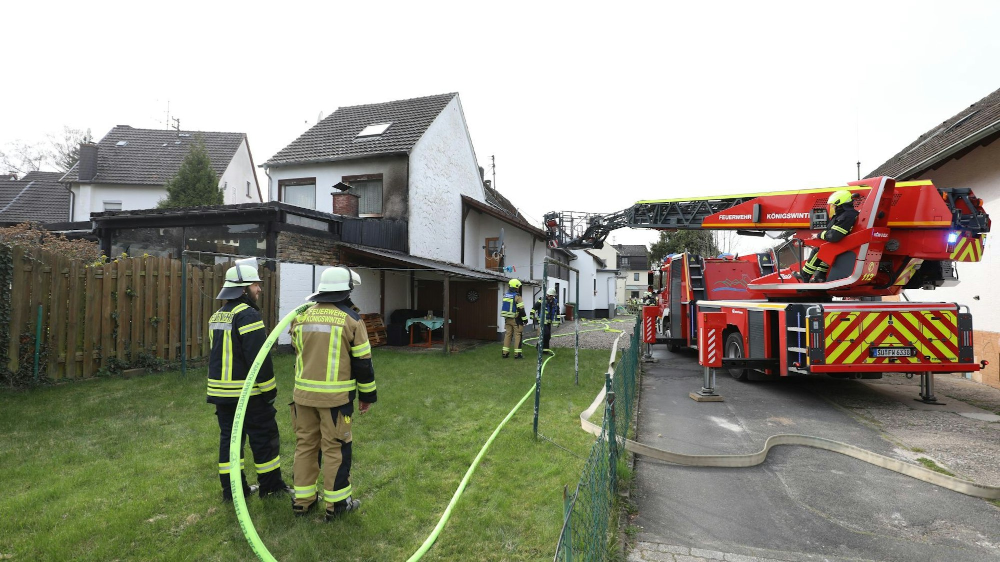 Eine Drehleiter der Feuerwehr und mehrere Feuerwehrleute.