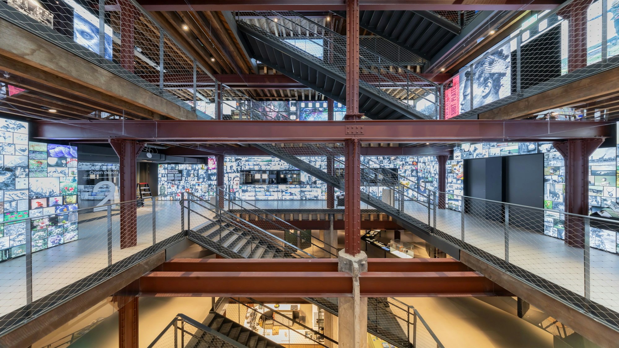 Leuchtende Bilderwände stehen in einem Fabrikgebäude.