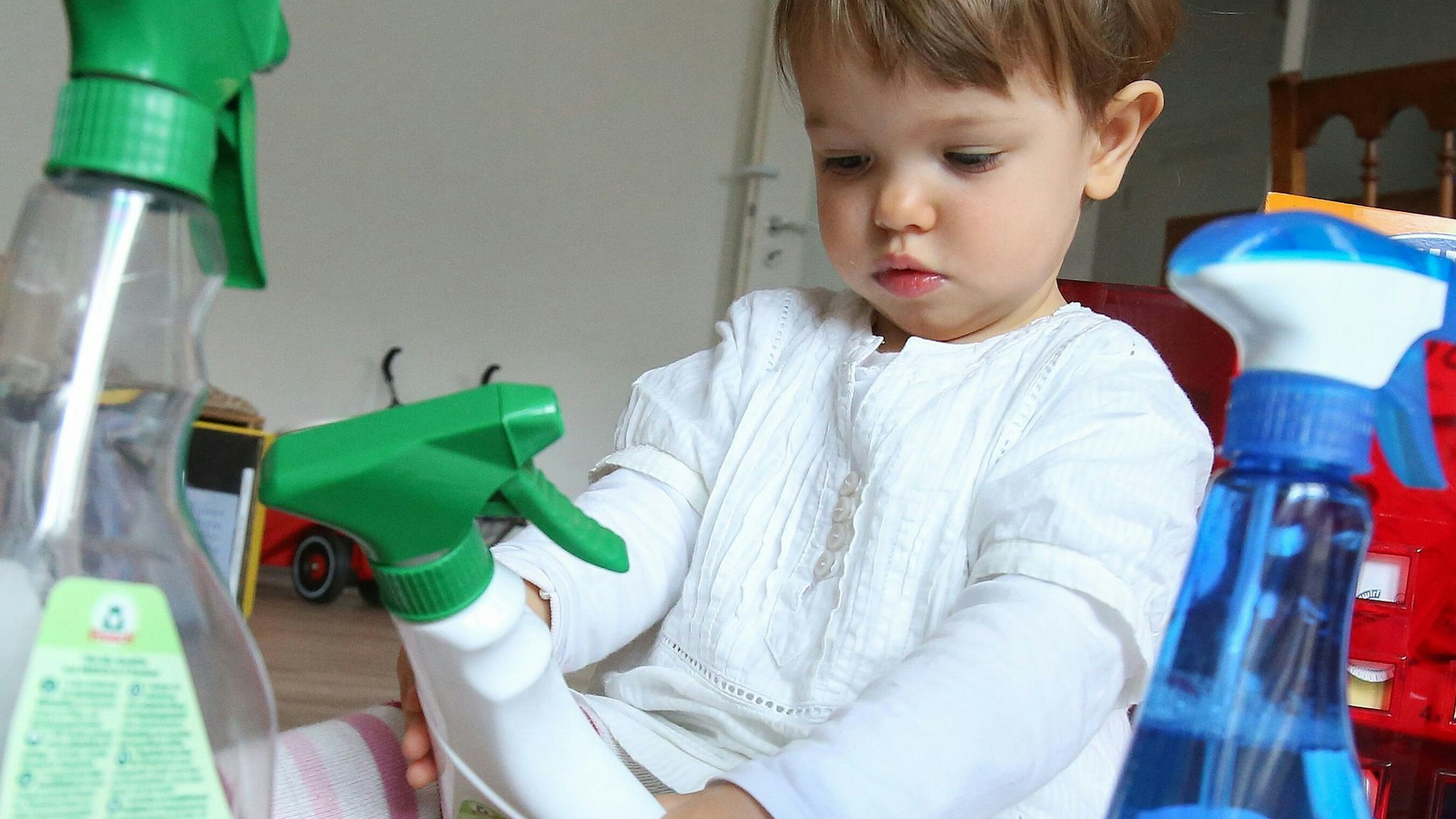 Mädchen spielt mit Putzmitteln