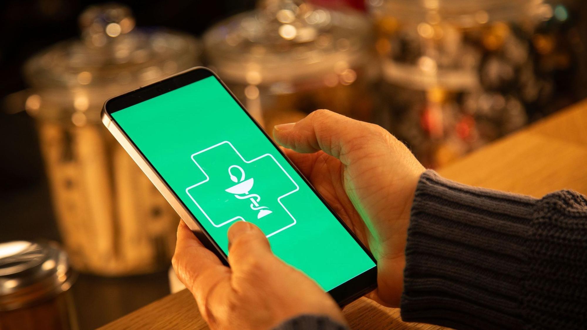 Eine Frau nutzt eine digitale Gesundheits App auf dem Handy