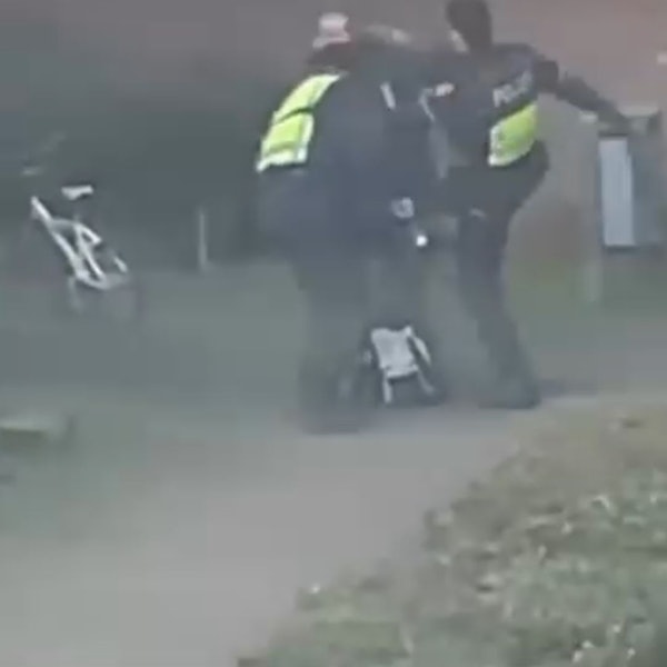 Zu sehen sind zwei Polizisten und ein Mann auf einer unscharfen Video-Aufnahme.