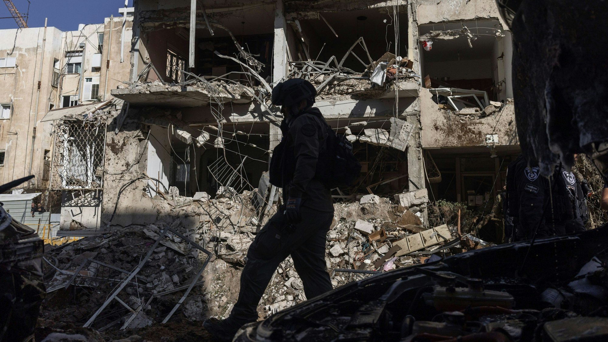 24.03.2026, Israel, Tel Aviv: Ein israelischer Soldat geht durch die Trümmer eines iranischen Raketenangriffs. Foto: Itai Ron/dpa +++ dpa-Bildfunk +++