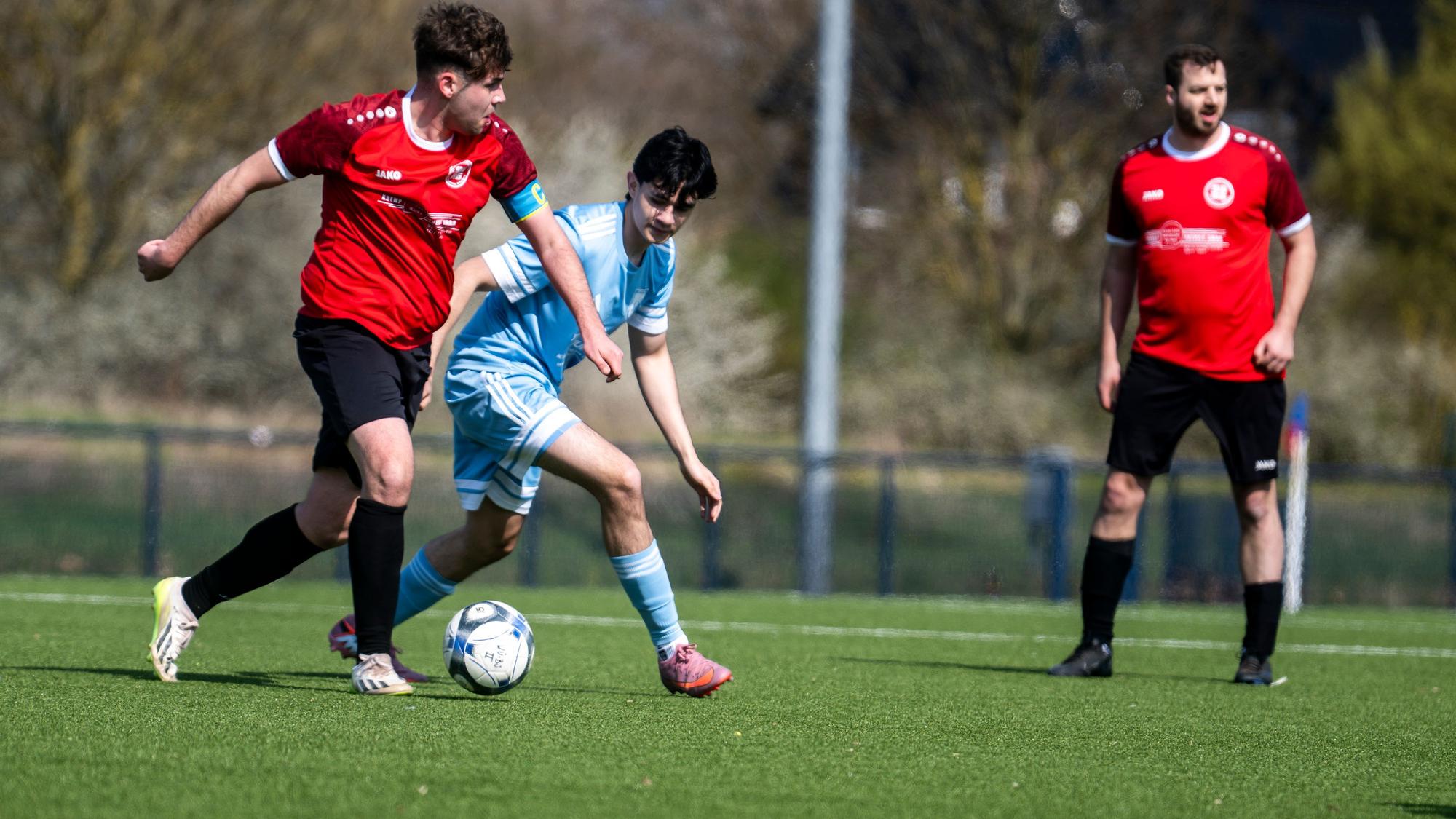 Ein Spieler der SG Rotbachtal/Strempt II sucht einen Passabnehmer, ein Gegenspieler von Wüschheim-Büllesheim II will das verhindern.