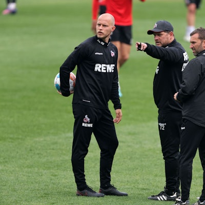 Steffen Baumgart zeigt René Wagner und André Pawlak etwas auf dem Trainingsplatz.