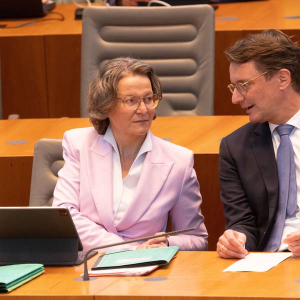 Ina Scharrenbach (CDU), Ministerin für Heimat, Kommunales, Bau und Gleichstellung von NRW, und Hendrik Wüst (CDU), Ministerpräsident von NRW, unterhalten sich im Plenum des Landtags.