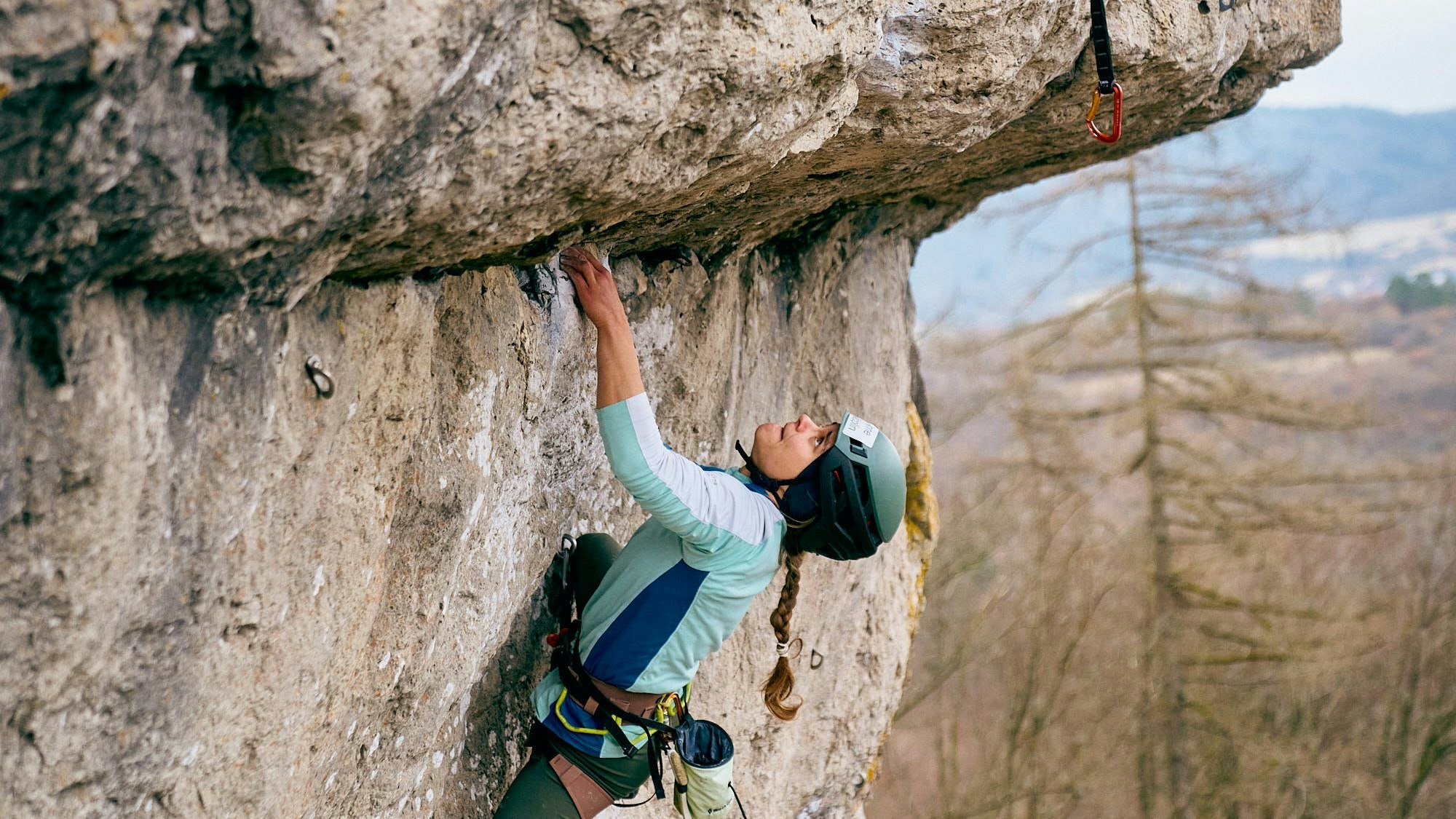 Ein junge Bergsteigerung an einem überhängenden Stück Felswand