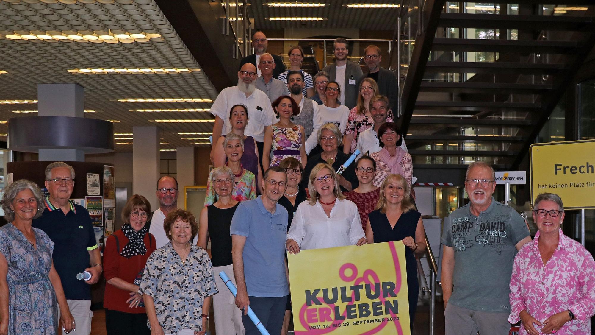 Auf dem Bild ist eine Gruppe von Menschen im Rathaus Frechen zu sehen.