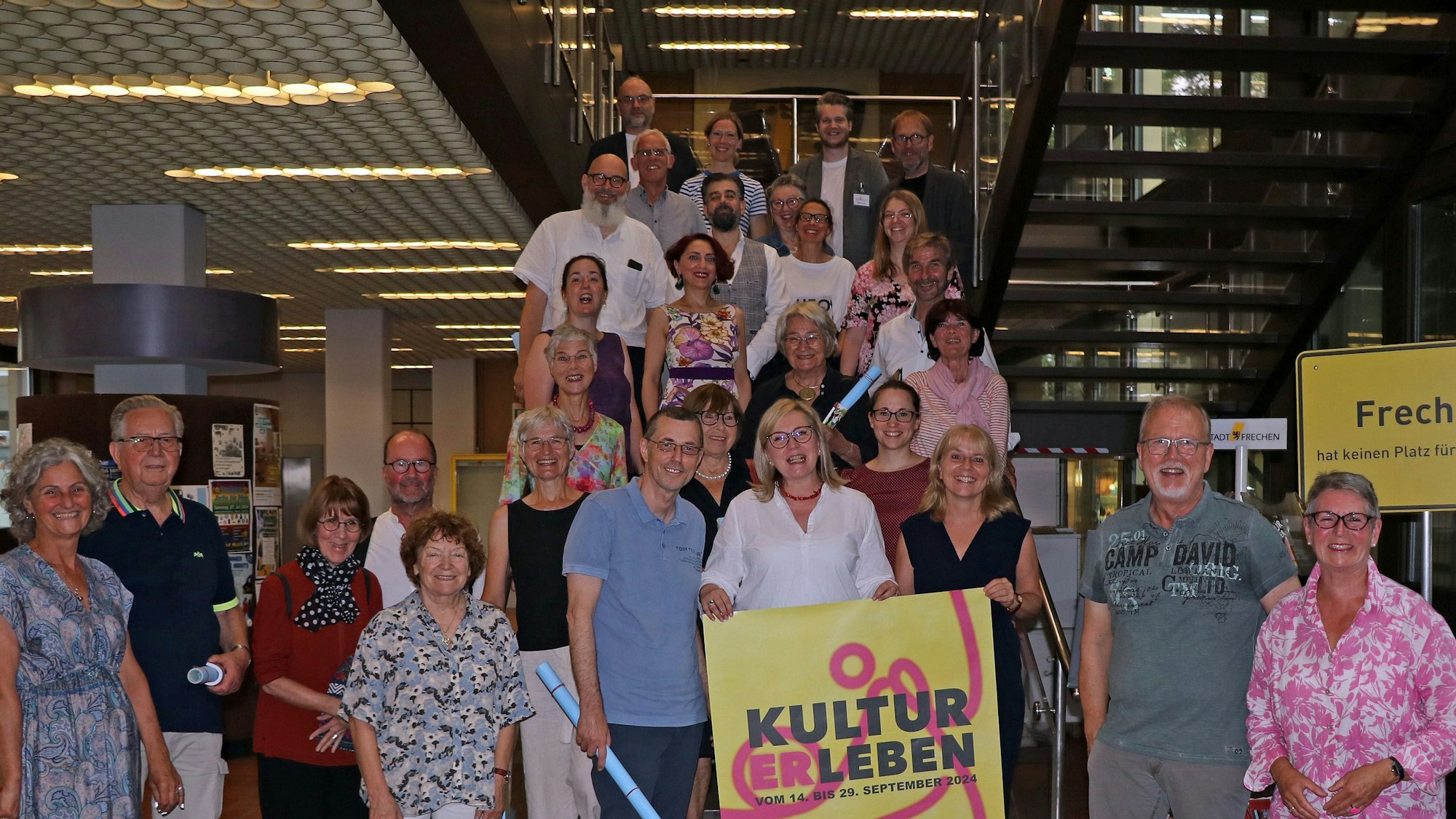 Auf dem Bild ist eine Gruppe von Menschen im Rathaus Frechen zu sehen.