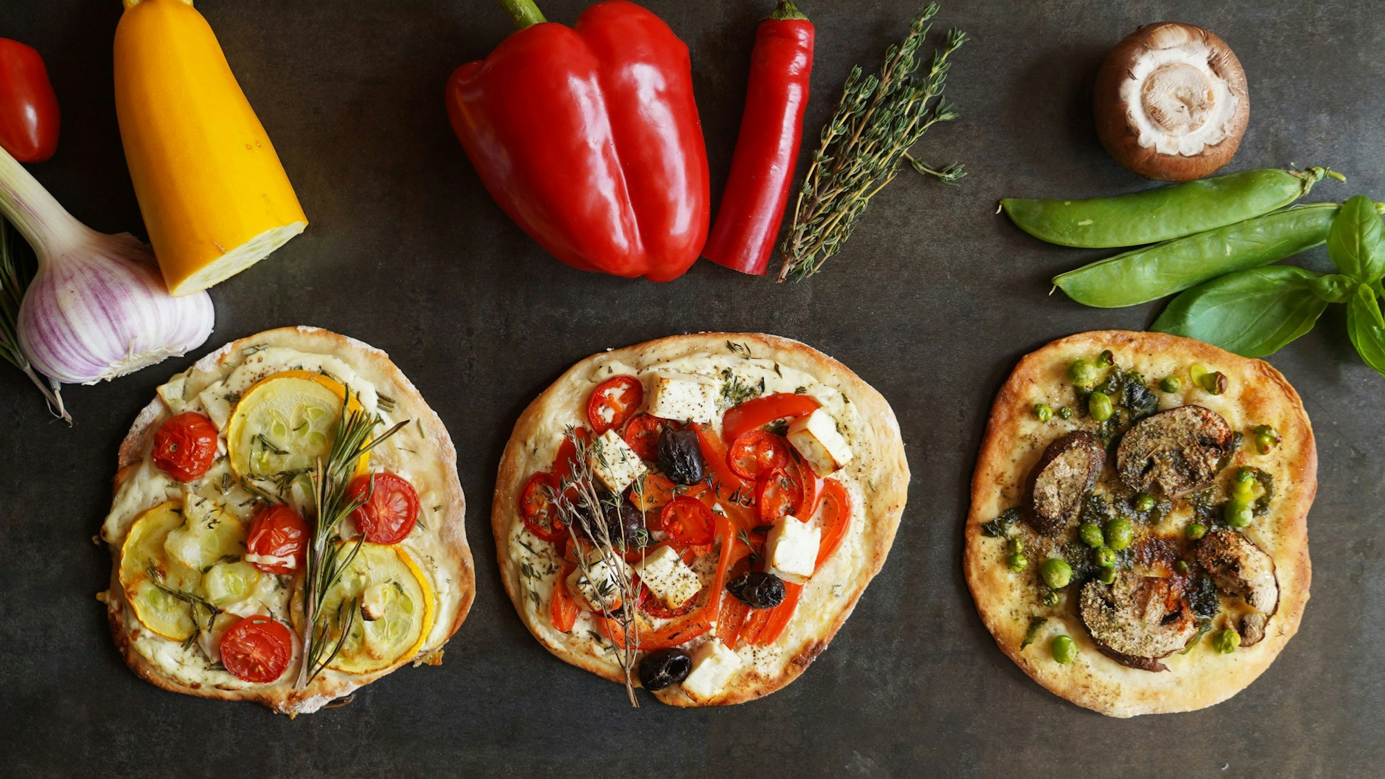 Gelbe Zucchini, rote Paprikaschoten oder grüne Erbsen - der Belag für die Mini-Pizzen erinnert an eine Ampel.
