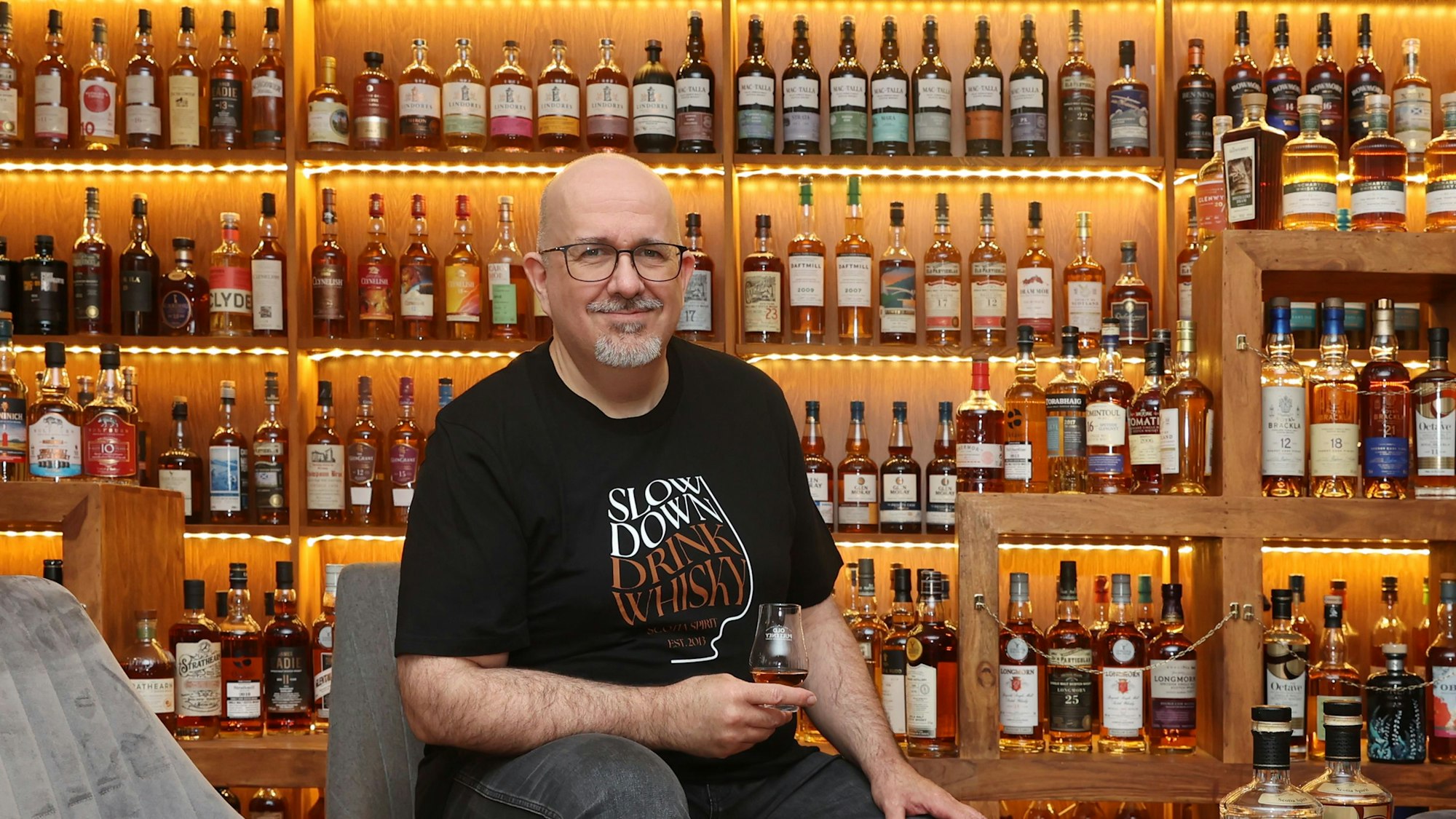 Peter Klas vor dem Regal mit den 500 Flaschen