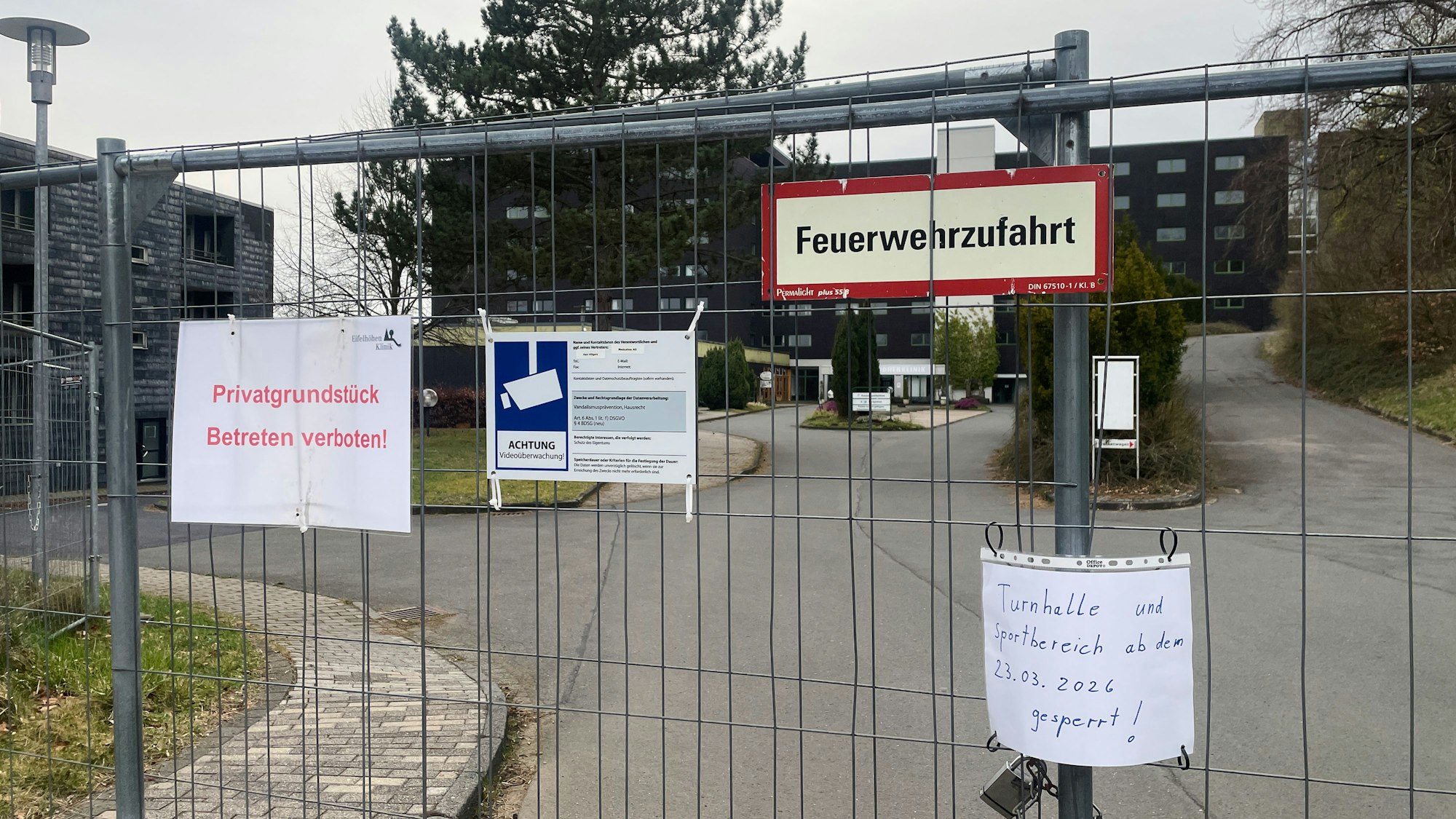 An der verschlossenen Zufahrt zum früheren Klinikgebäude weist ein Zettel darauf hin, dass Turnhalle und Sportbereich gesperrt sind.
