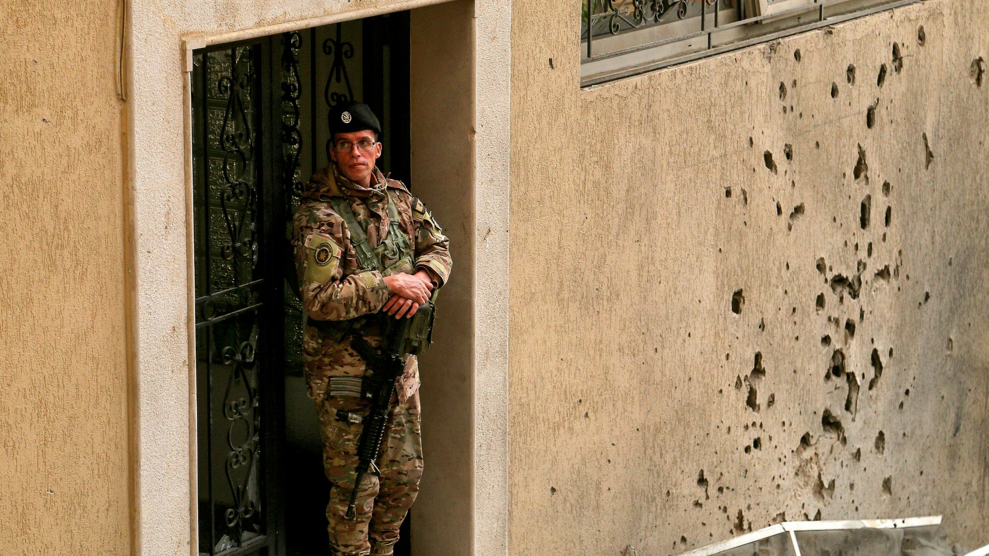 Ein libanesischer Soldat steht neben einer von Granatsplittern durchlöcherten Mauer, nachdem eine iranische Rakete abgefangen wurde.