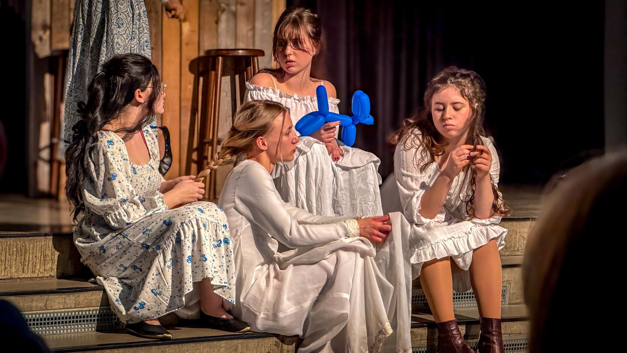 Schülerinnen spielen Theater auf einer Bühne.