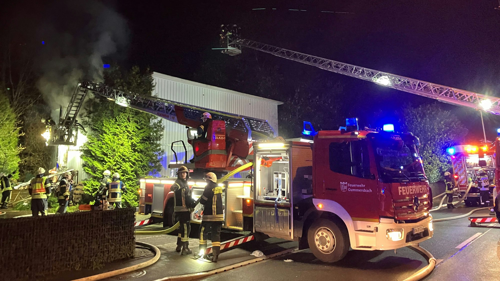 Feuerwehrleute bei einem Fassadenbrand im Einsatz.