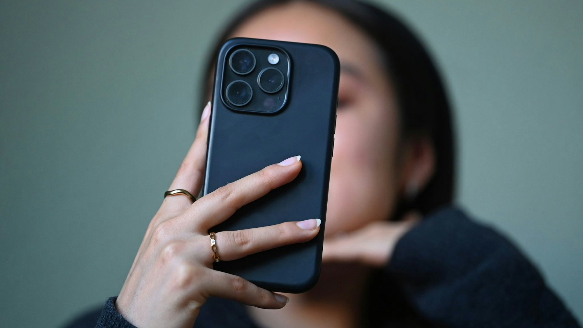 Eine Frau hält ein Handy in der Hand.