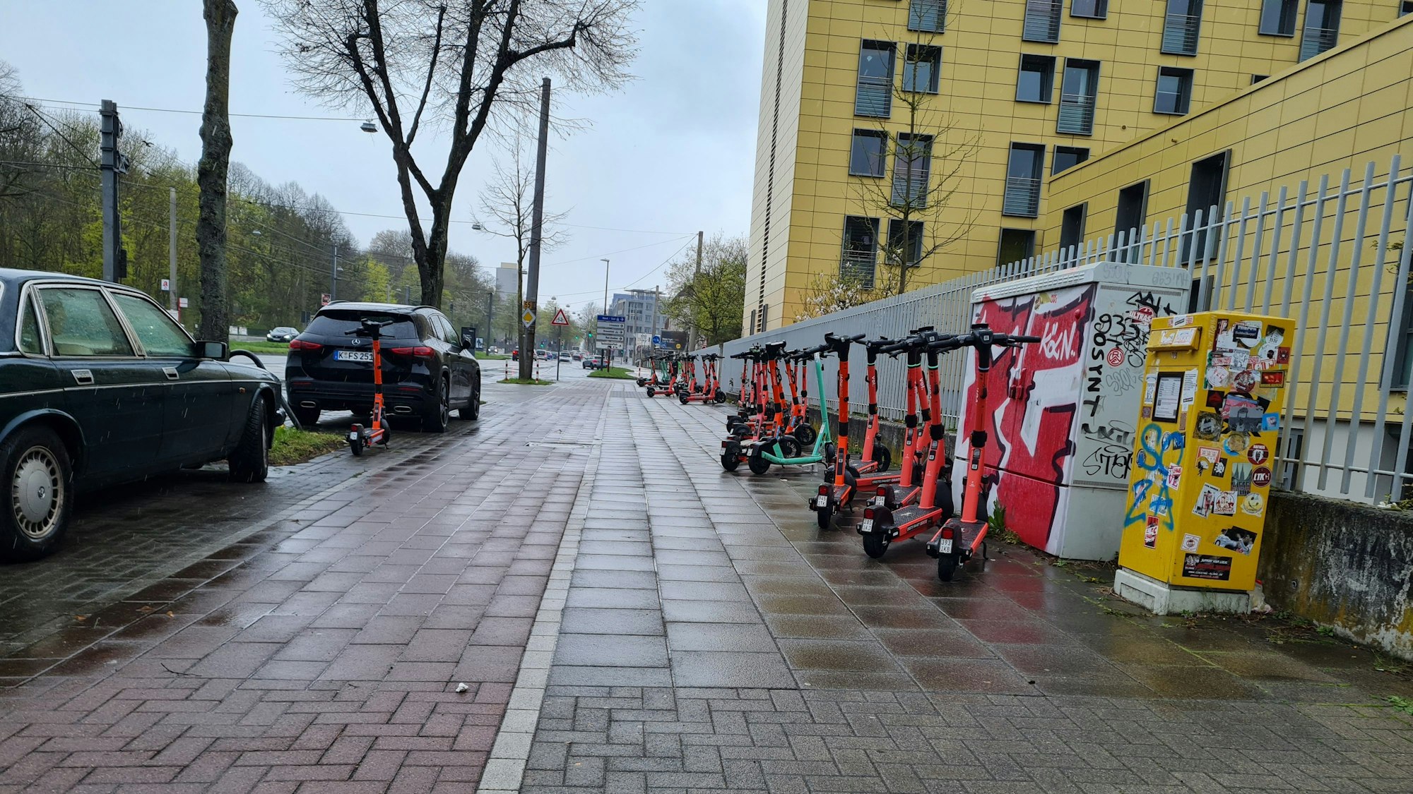 30 E-Scooter stehen auf dem Gehweg, zum Großteil am Rand und nicht im Weg