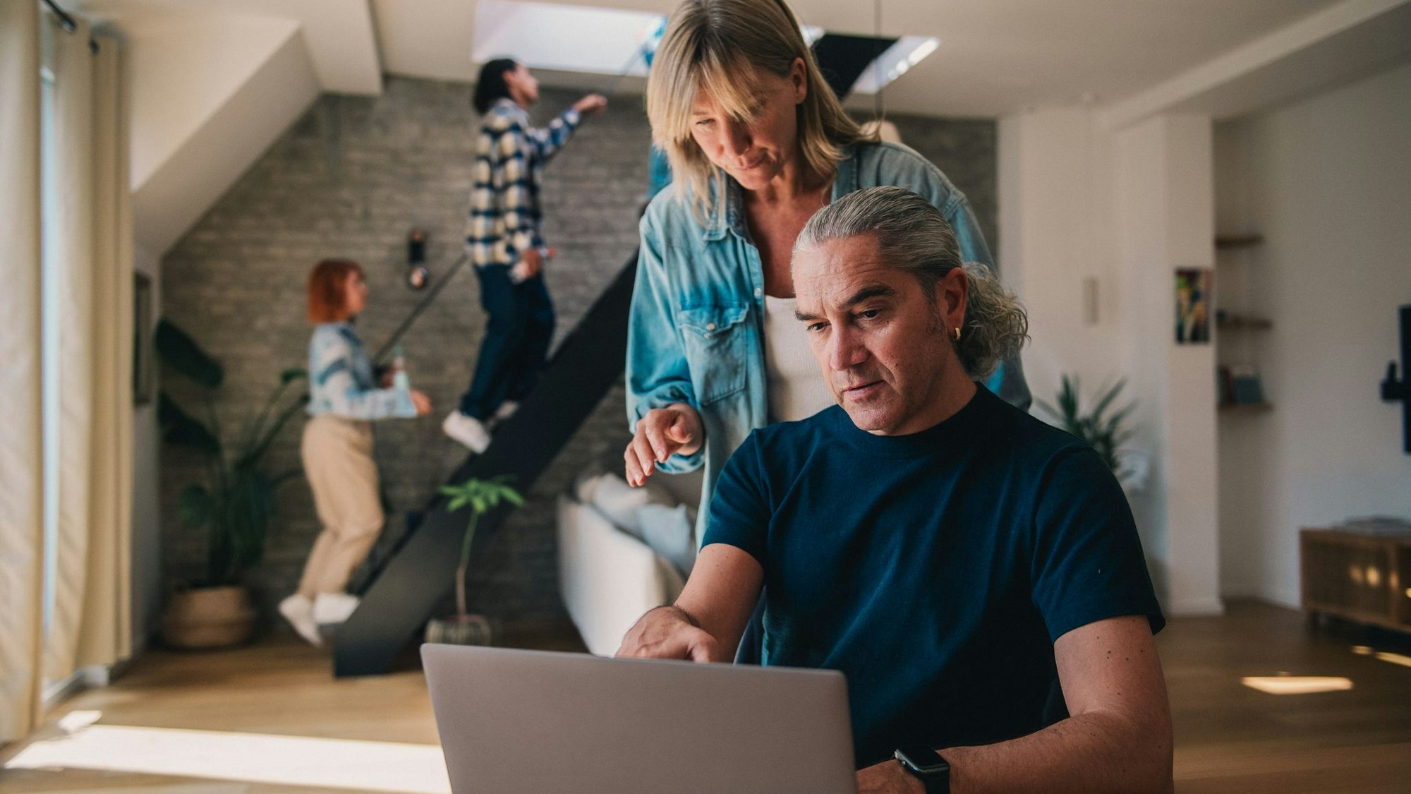 Ein Mann und eine Frau blicken auf einen Laptop