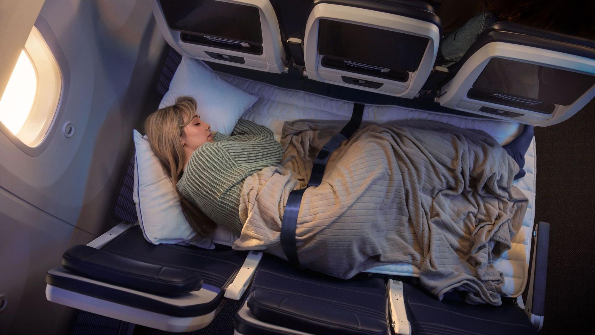 Eine Frau liegt auf drei Sitzen im Flugzeug