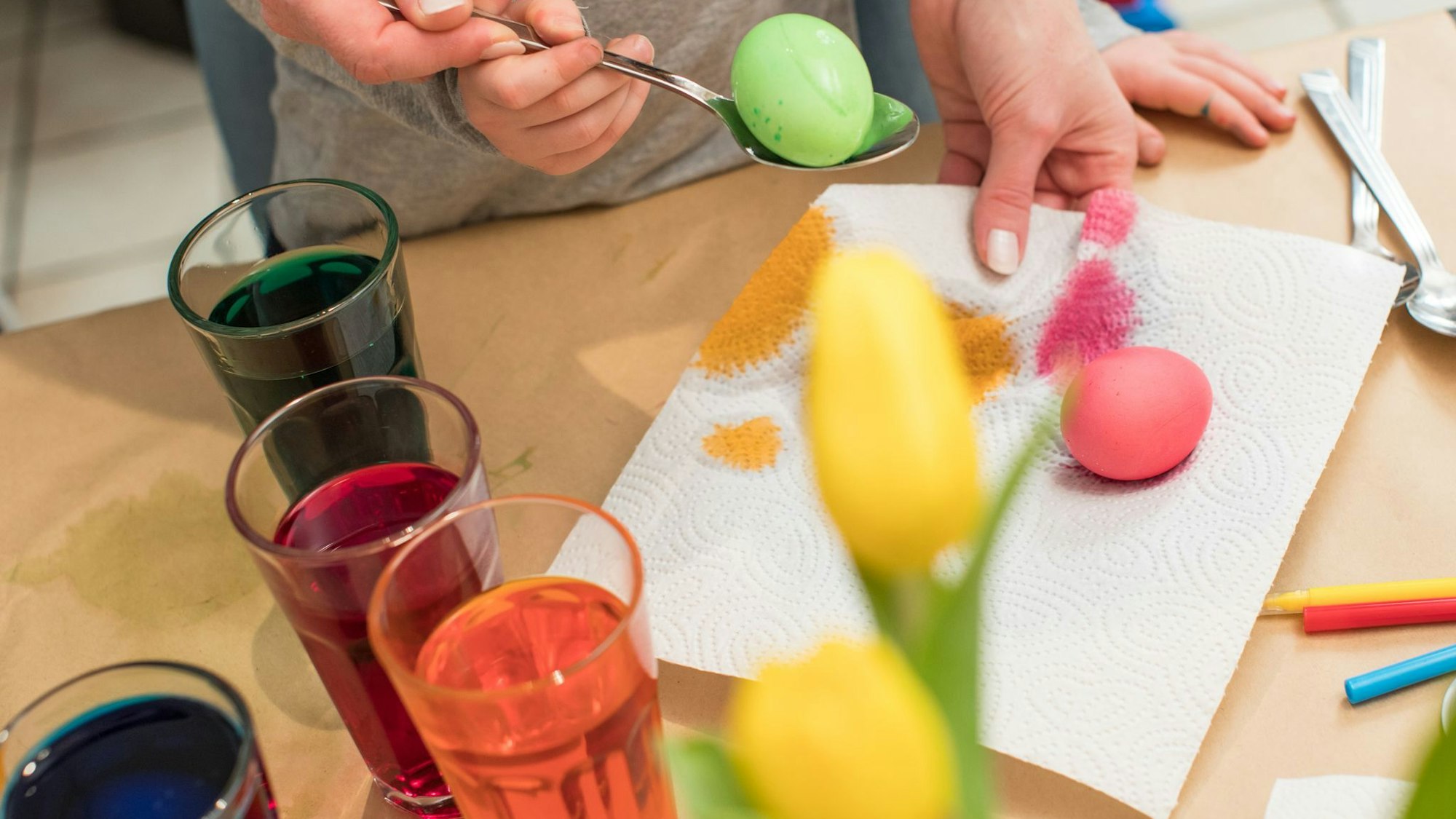 Ein Junge und seine Mutter beim Ostereier färben