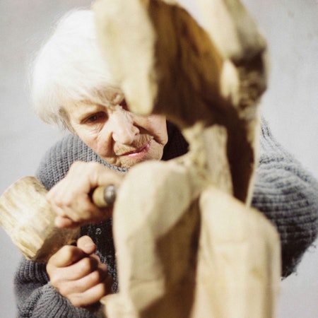 Louise Stomps arbeitet mit Hammer und Holzspachtel an ihrer letzten Skulptur „Der Aussteiger“.