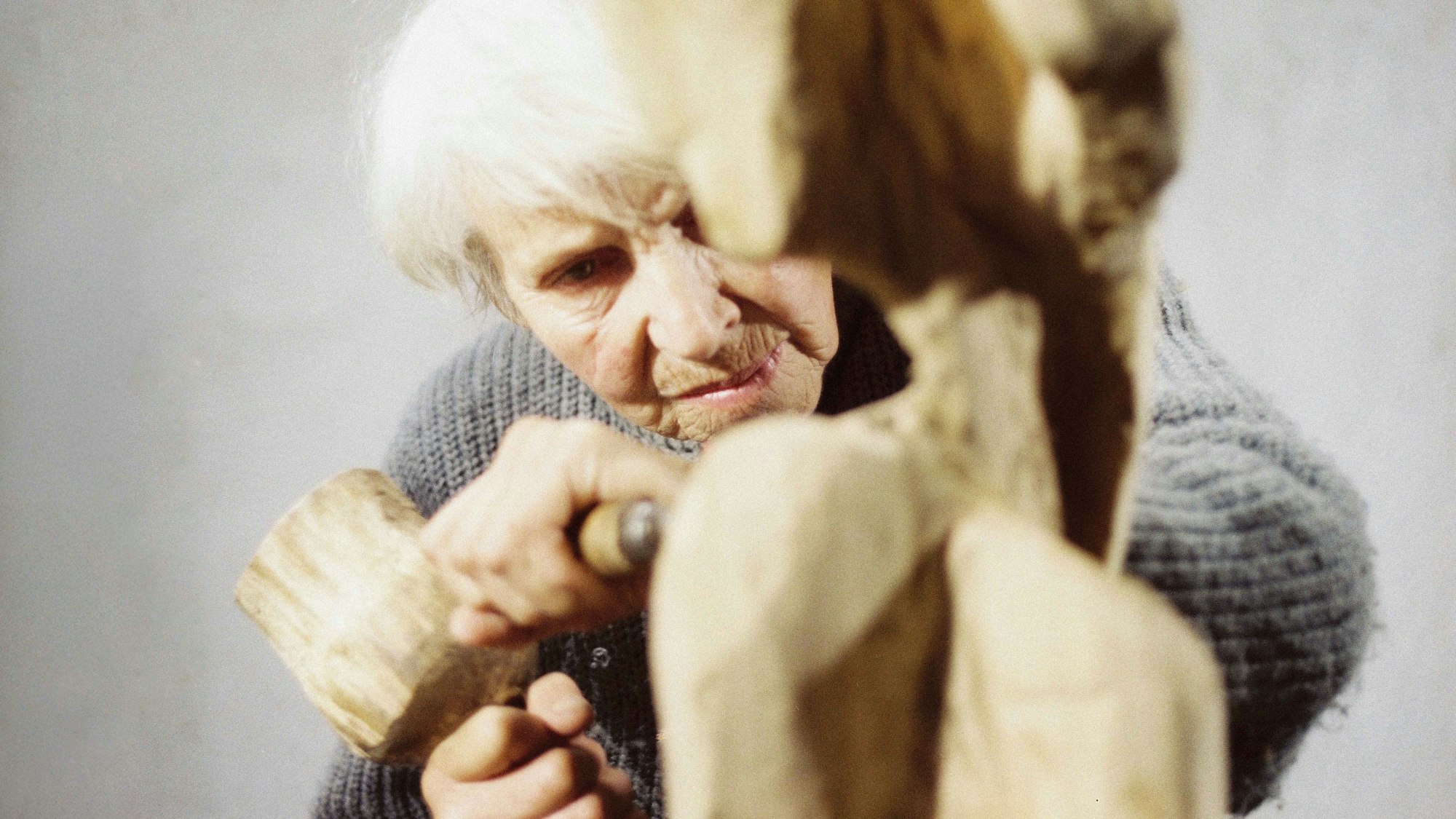 Louise Stomps arbeitet mit Hammer und Holzspachtel an ihrer letzten Skulptur „Der Aussteiger“.