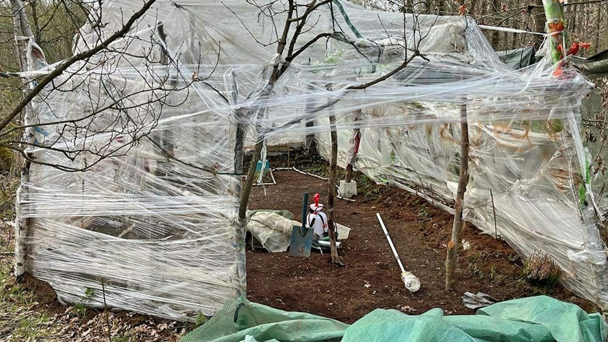 Stöcke mit Plastikfolie grenzen einen Bereich ein.