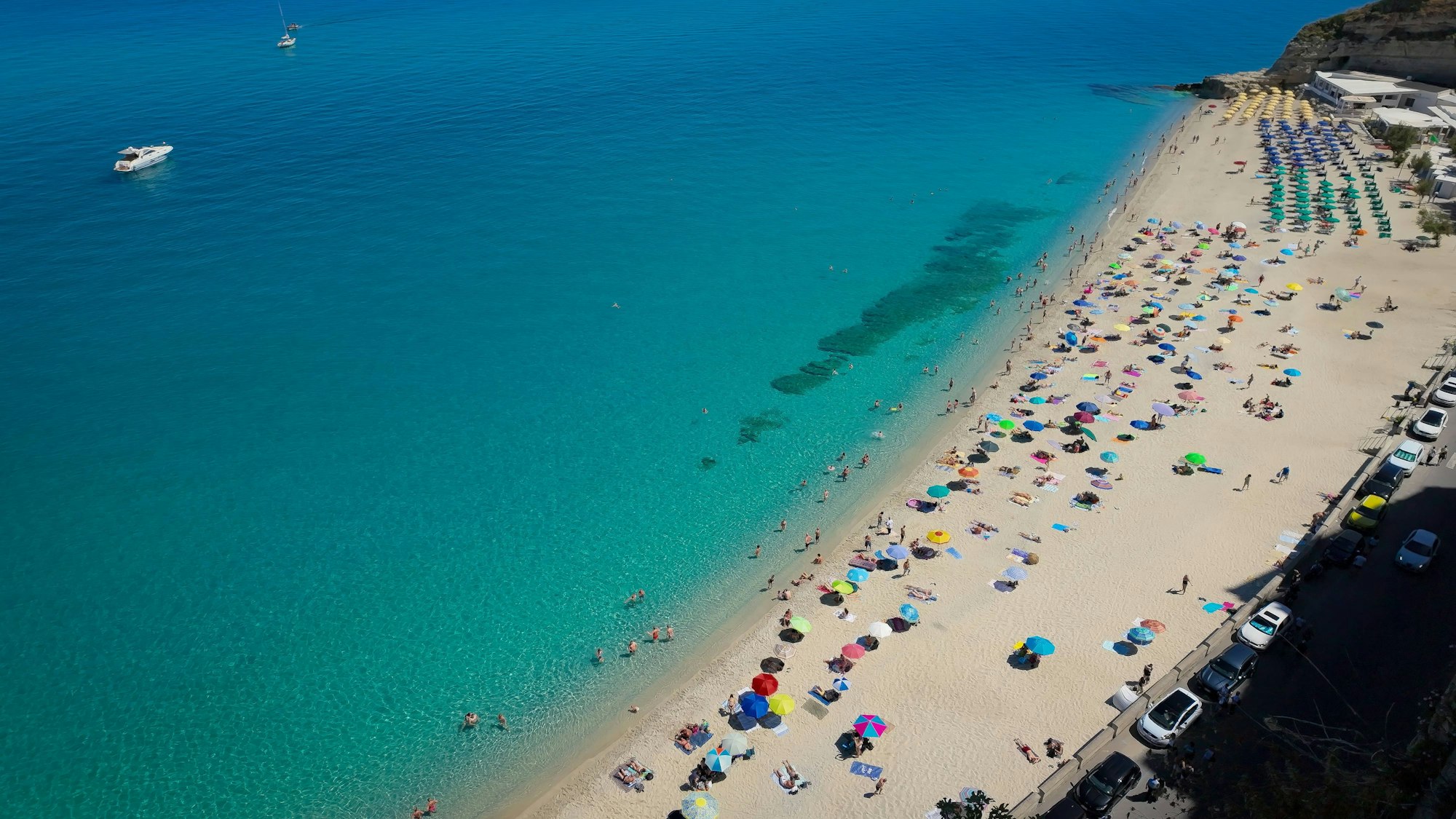 Touristen beim Entspannen am Strand von Tropea in Italien.