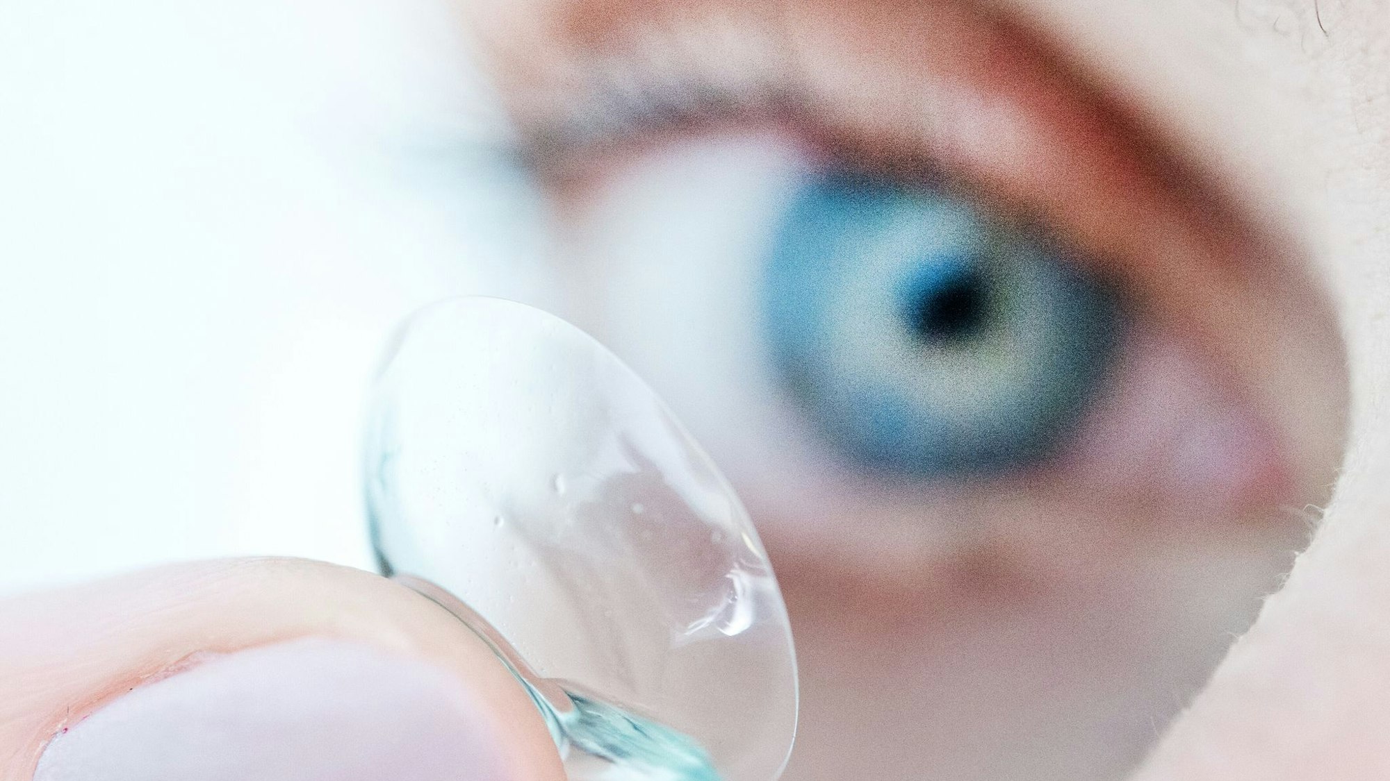 Eine Person hält eine Kontaktlinse auf dem Finger