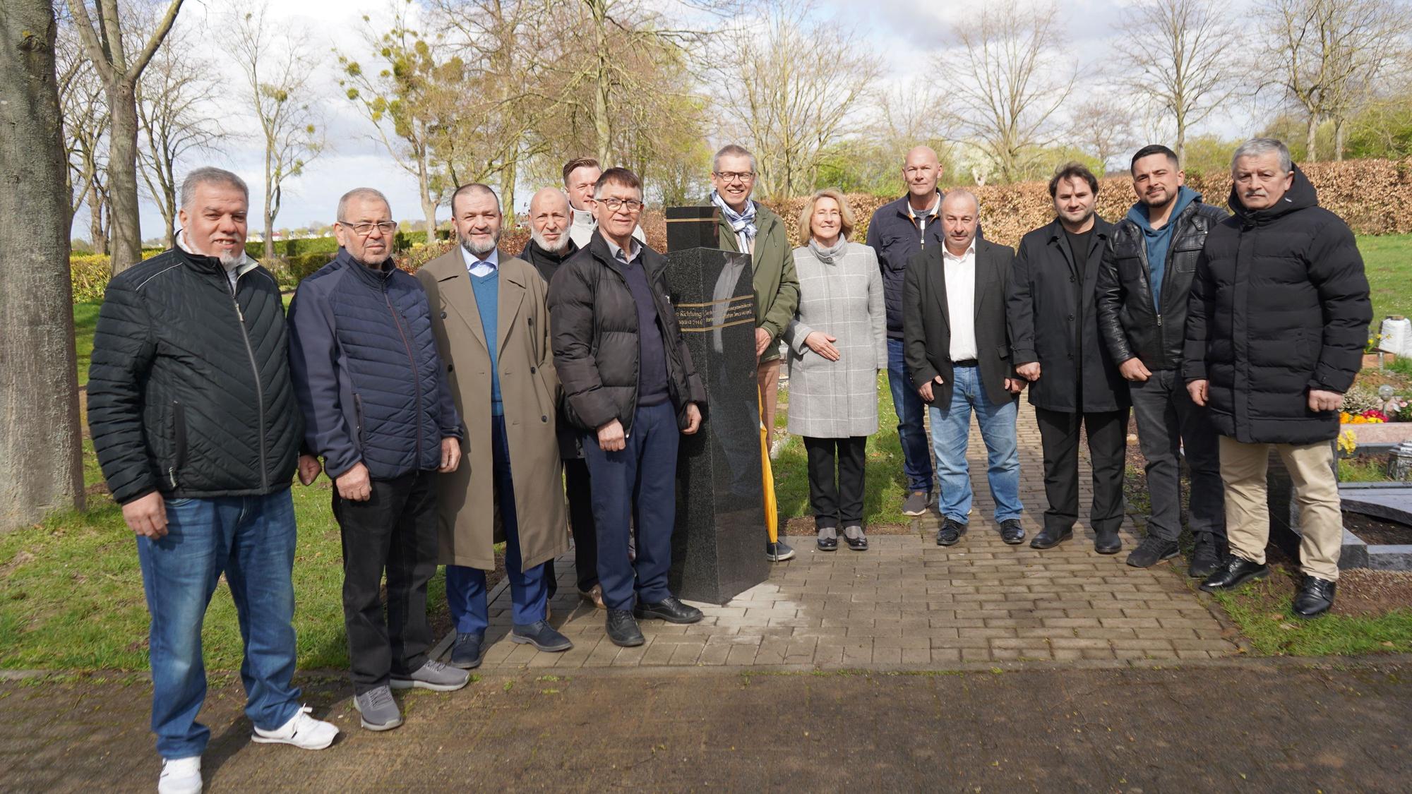 Das Bild zeigt die Menschen, die sich um die Stele versammelt haben.