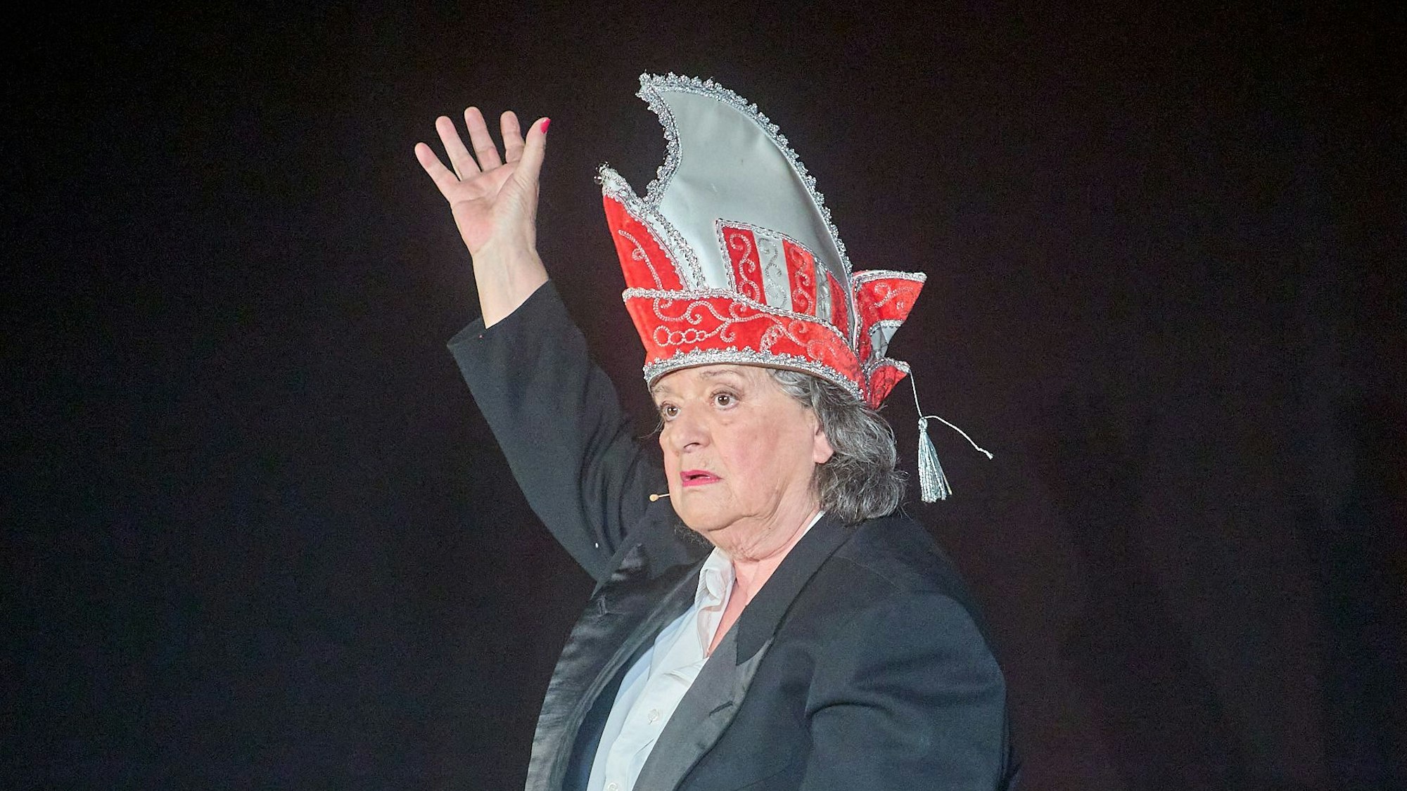 Biggi Wanninger steht mit einer Narrenkappe auf der Bühne