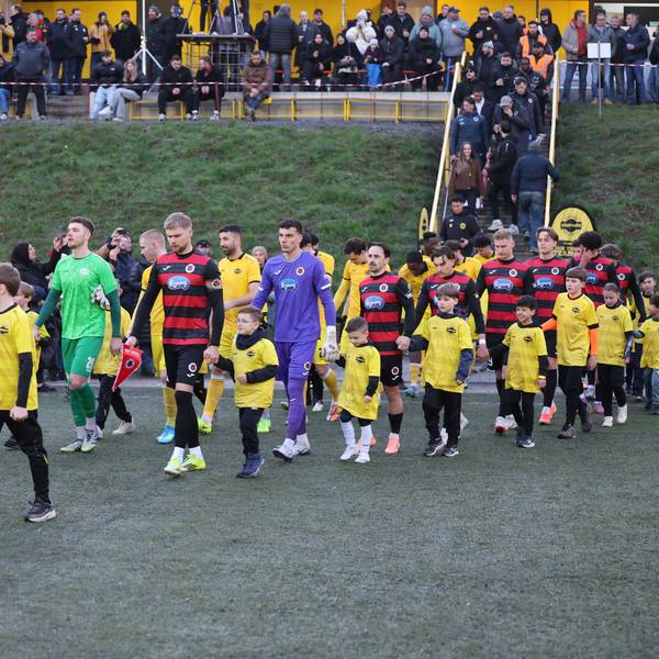 Die beiden Mannschaften laufen mit den Nachwuchskicker ins Achim-Lammers-Stadion in Köttingen ein.
