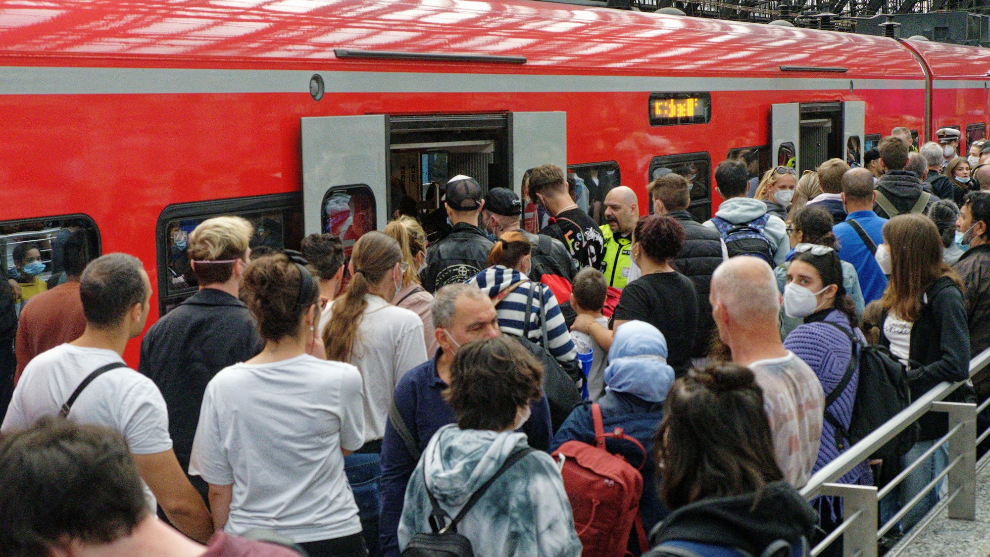 Reisende versuchen auf einem überfülltem Bahnsteig im Hauptbahnhof in einen Regionalzug zu steigen. Nach dem Start des 9-Euro-Tickets wird zum Ende des langen Pfingstwochenendes am Montag in Nordrhein-Westfalen eine starke Rückreisewelle erwartet. +++ dpa-Bildfunk +++