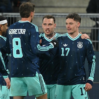 Florian Wirtz feiert mit seinen Mitspielern sein Tor.