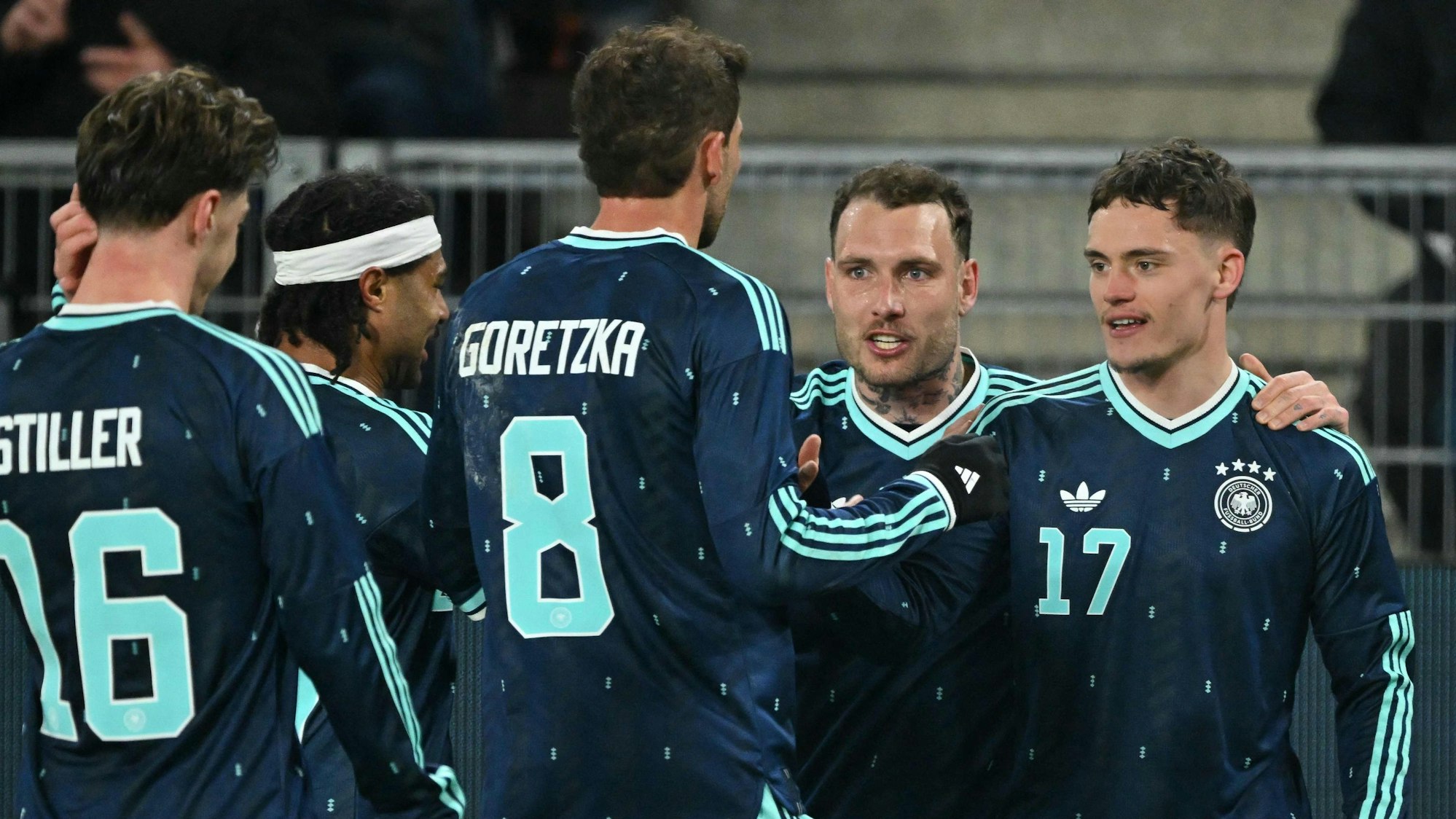 Florian Wirtz feiert mit seinen Mitspielern sein Tor.