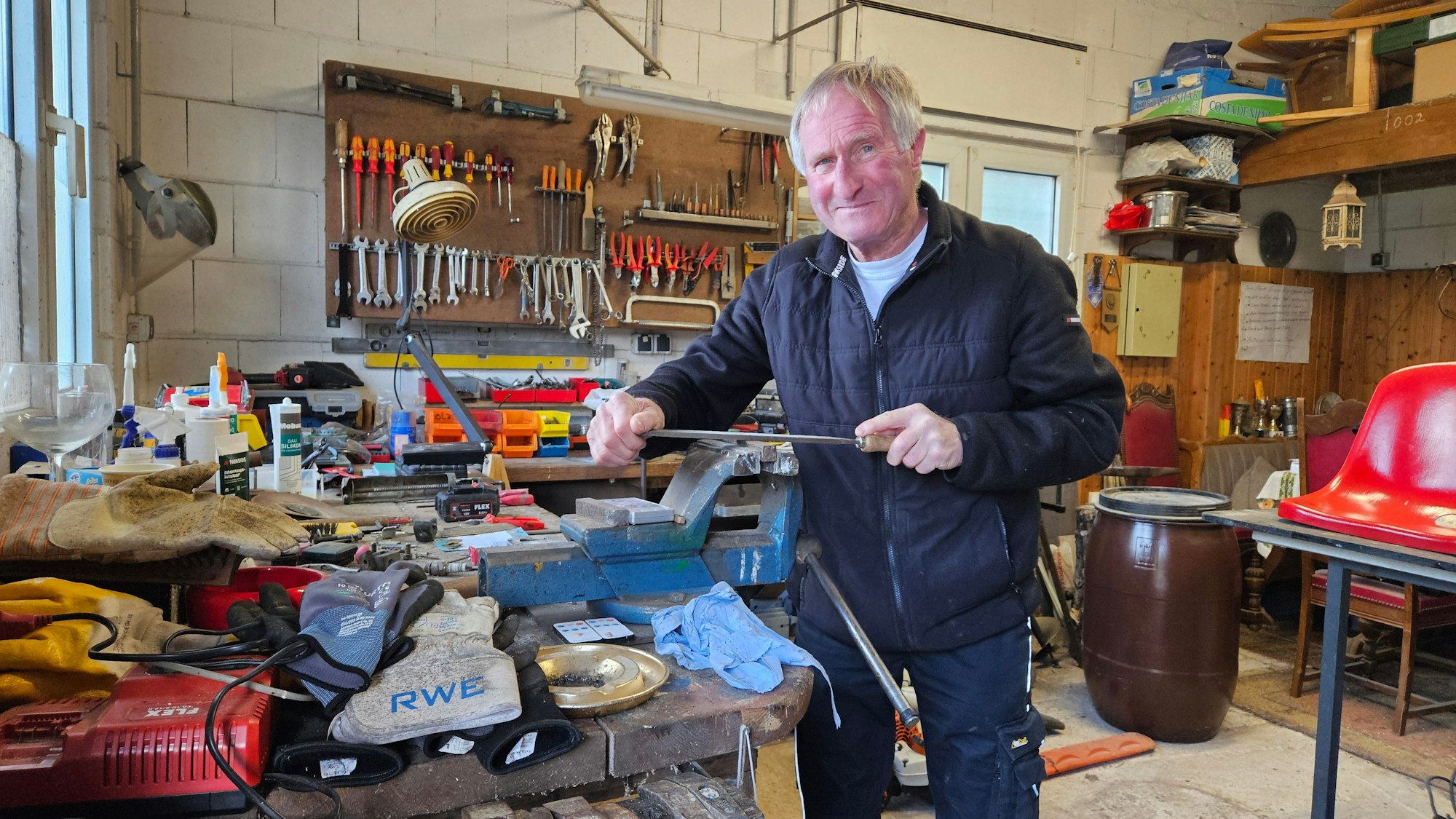 Zu sehen ist Gerd Wieland in einer Werkstatt mit zahlreichen Werkzeugen.