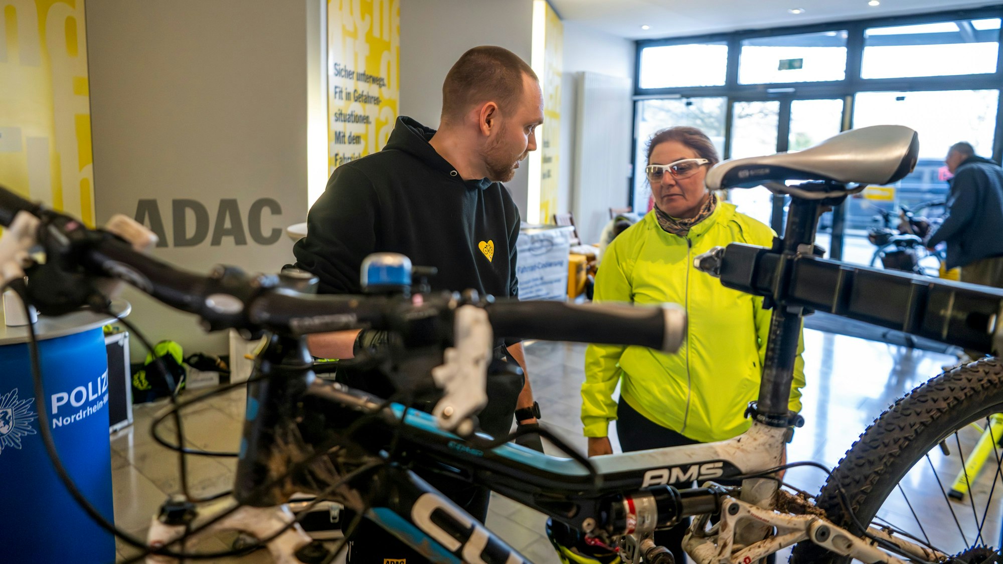 Das Bild zeigt den ADAC-Fahrradprüfer im Gespräch mit einer Frau, die ihr Mountainbike checken ließ.