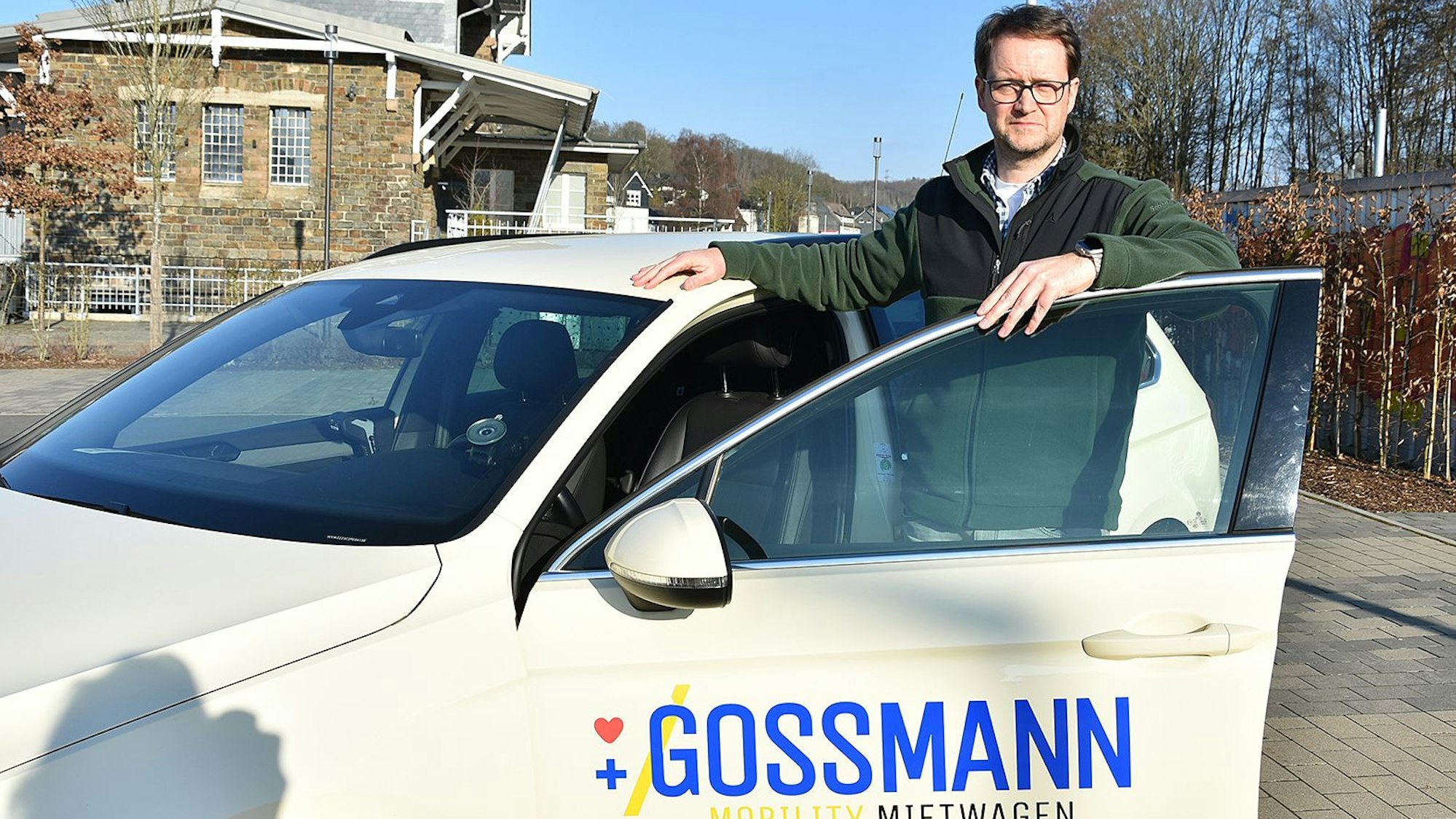 Ein Taxiunternehmer steht vor einem seiner Taxis.