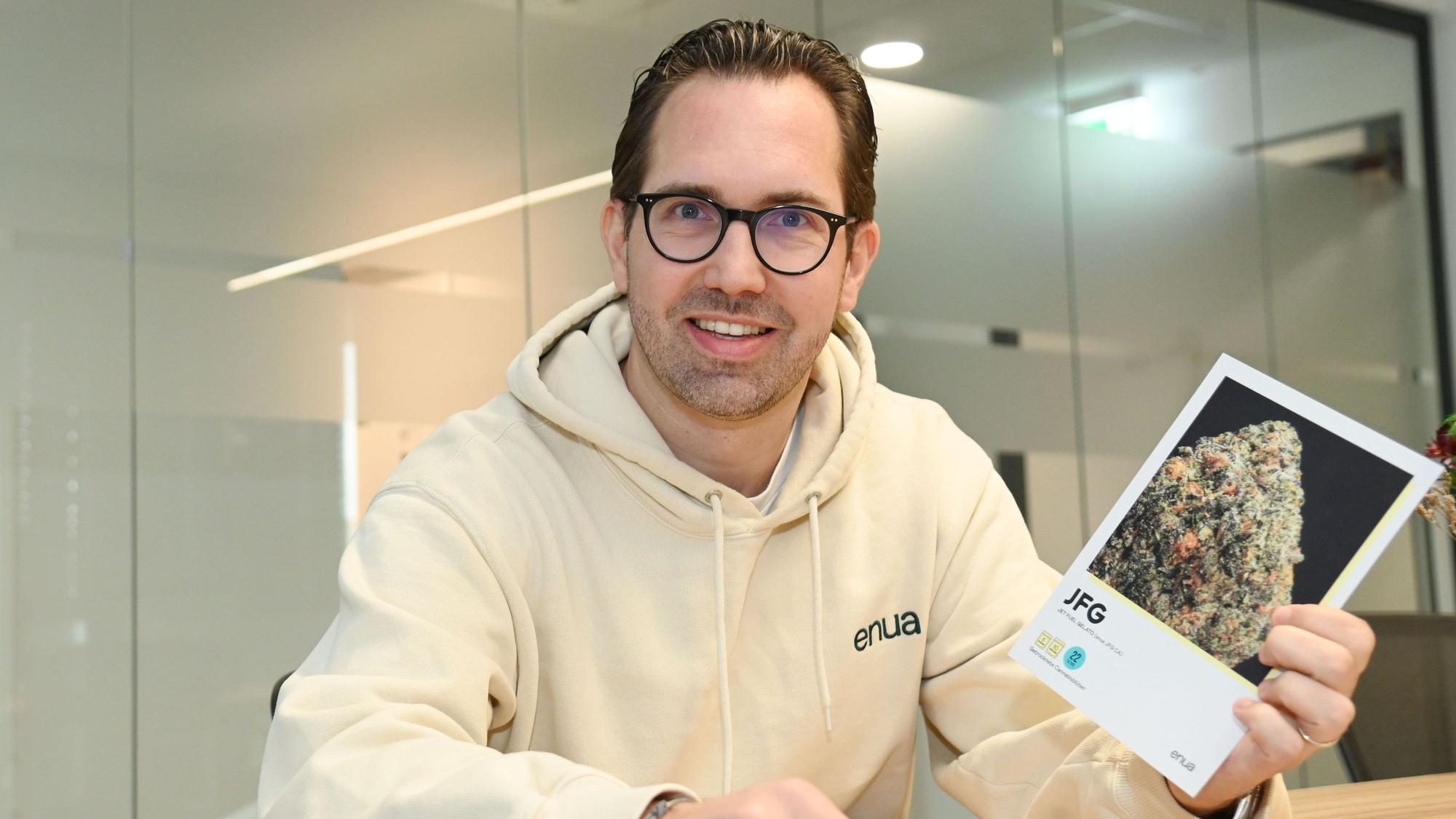 Albert Schwarzmeier zeigt eine Informationskarte, auf der die Eigenschaften einer Cannabis-Sorte (Strain) erklärt werden.
