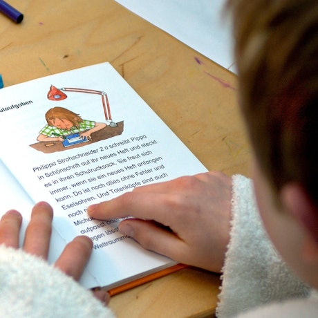 Ein Kind liest aus einem Buch.