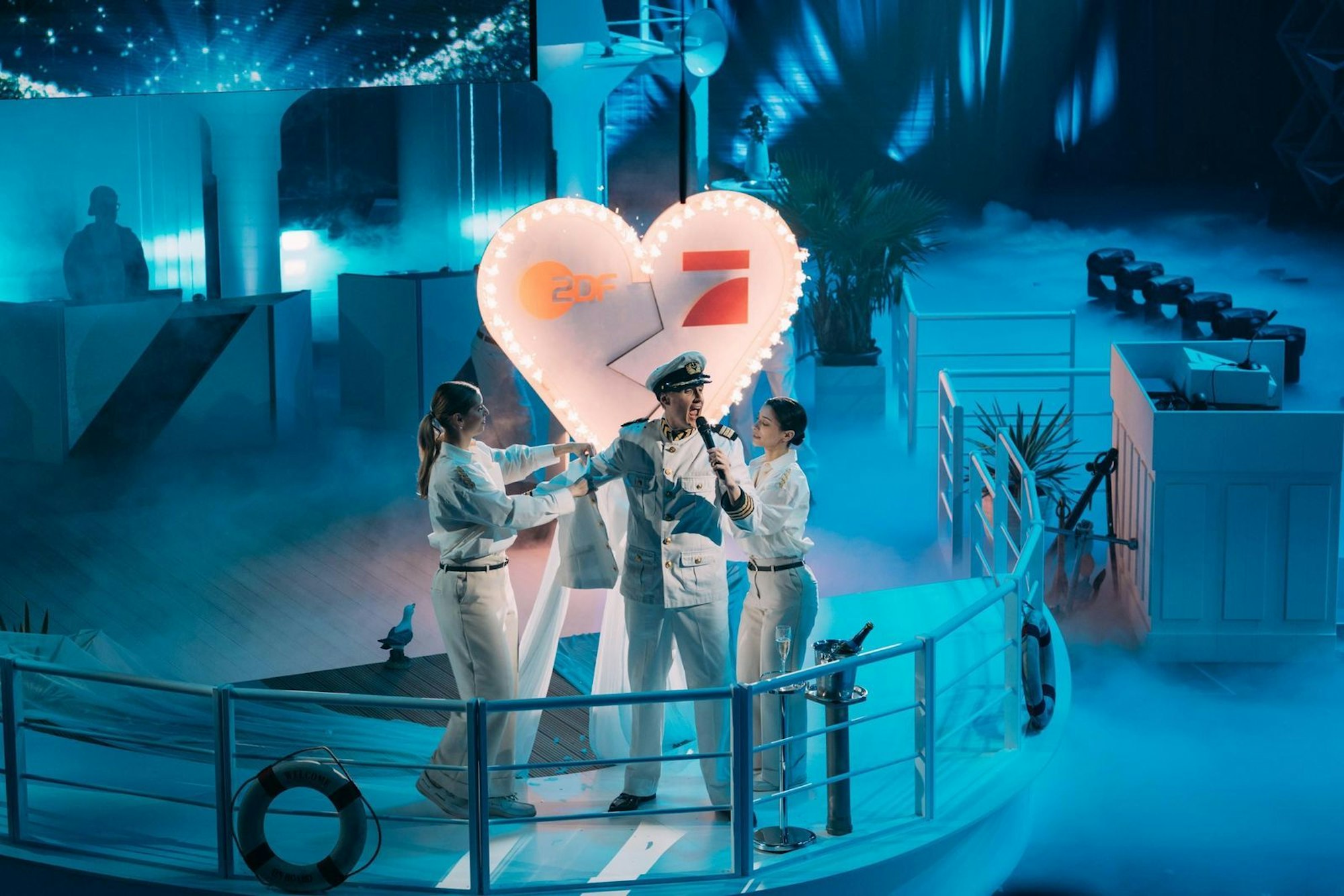 Till Reiners steckt in einer blütenweißen „Traumschiff“-Uniform. Er feiert die Vereinigung von ProSieben und ZDF - in einem maritimen Ambiente mit viel Liebe zum Detail. (Bild: Joyn/Florida TV / Julian Mathieu)