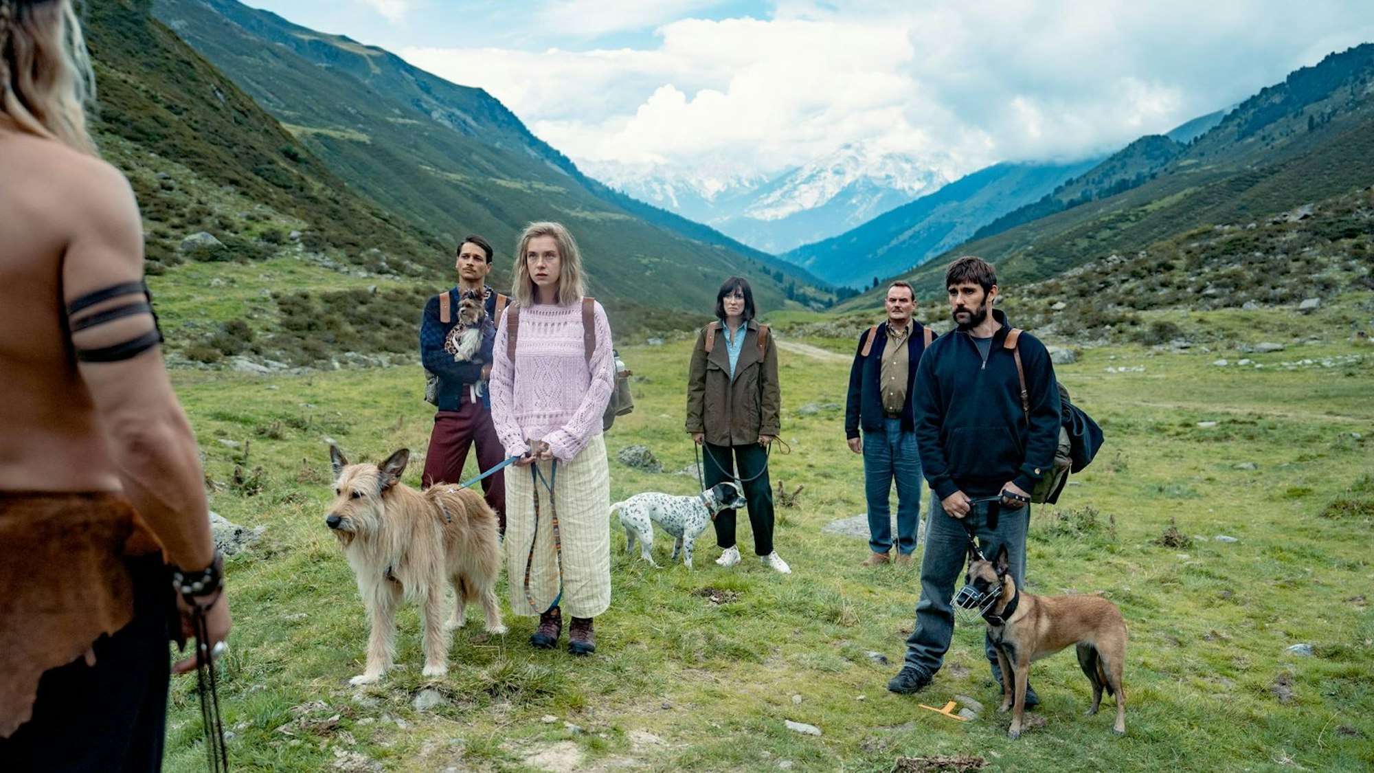Fünf Hundehalter (von links: Doga Gürer, Anna Herrmann, Alexandra Maria Lara, Devid Striesow und Kerim Waller) stellen sich der „keltischen“ Hundetherapie von Nodon (Rúrik Gíslason, ganz links im Anschnitt). (Bild: © Sasha Ostrov / Netflix)