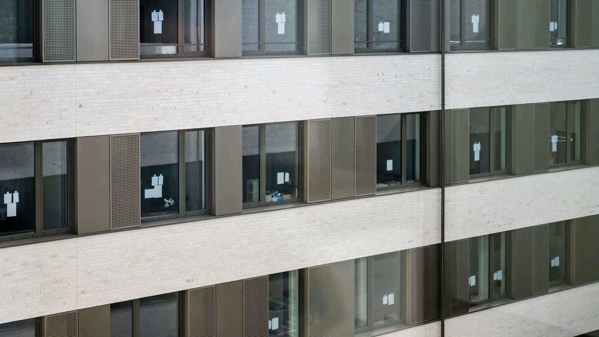 An den Bürofenstern hängen kleine weiße Zettel.